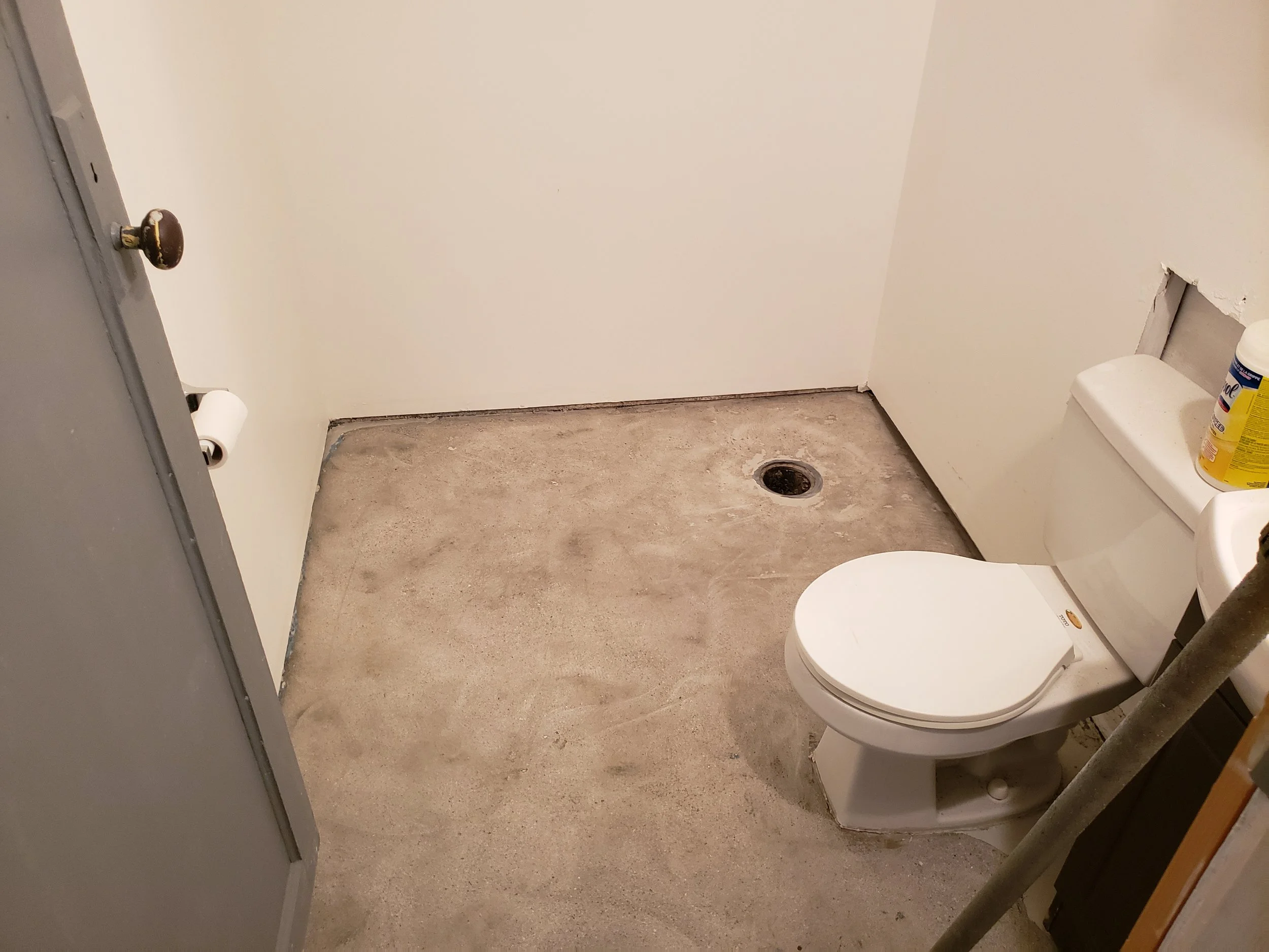 Basement bathroom floor, bare concrete, unfinished. 