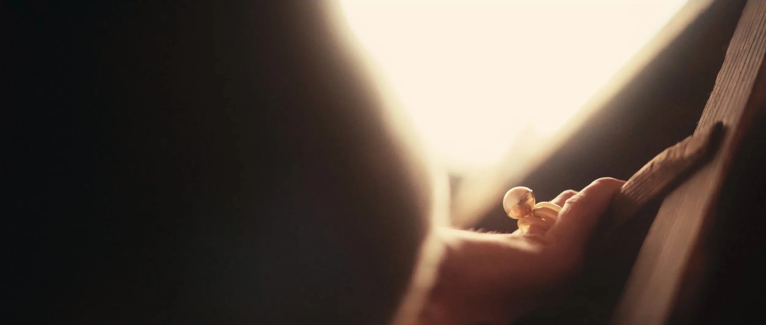 Close-up of light bulb and hand flipping a light switch in a dark room