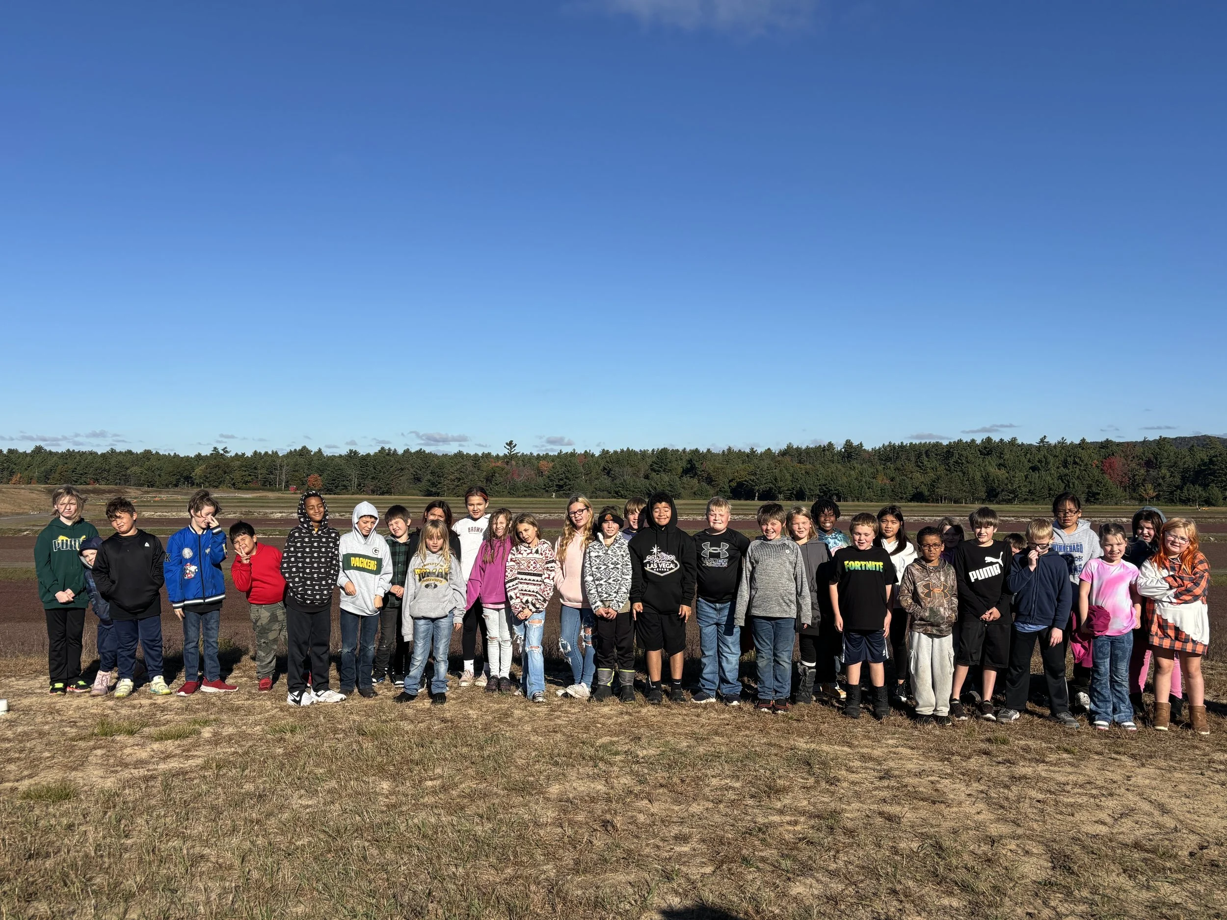 Elementary school tour standing in front of the cranberry bed