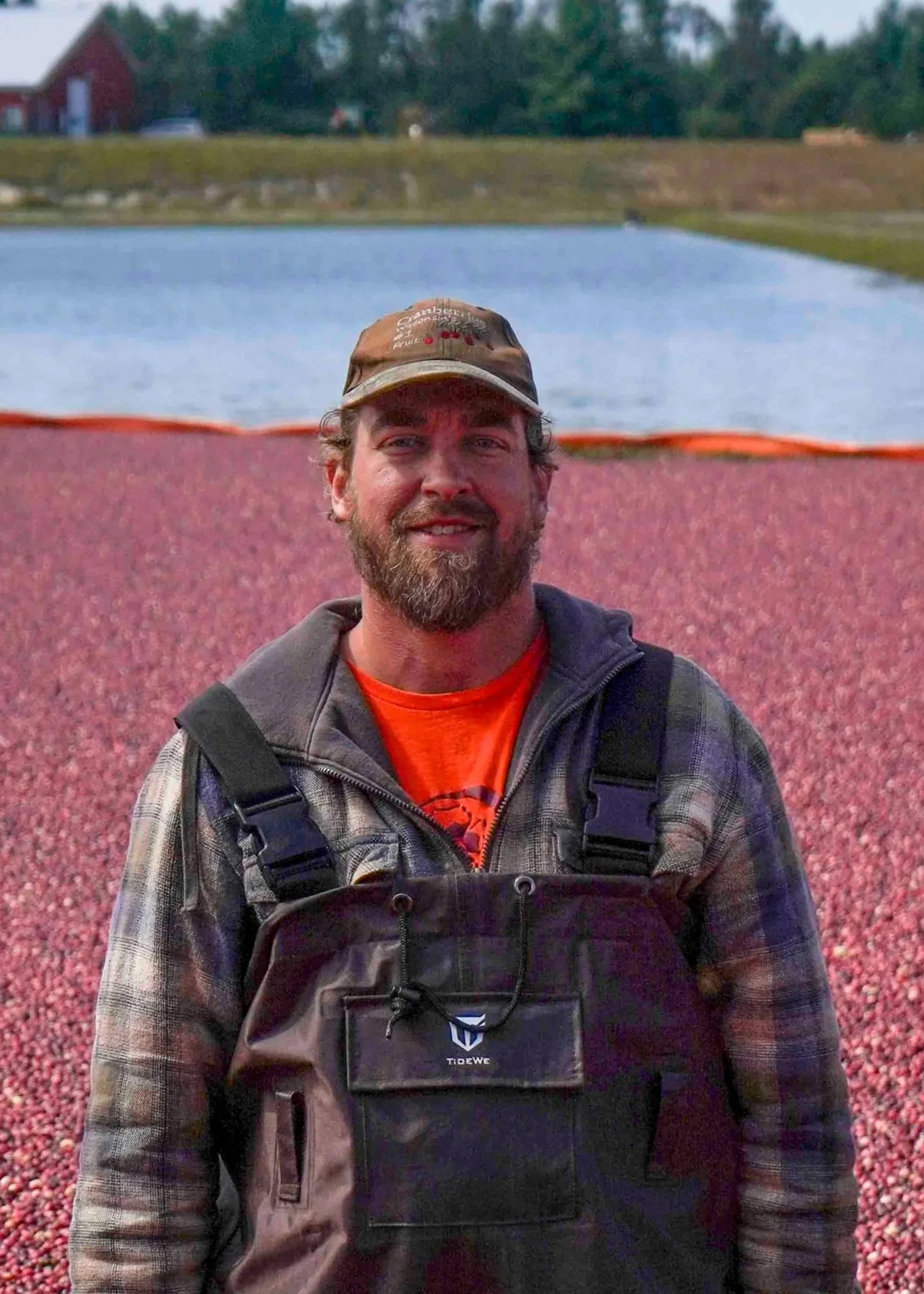 Headshot of Max standing in a cranberry bed with floating cranberries