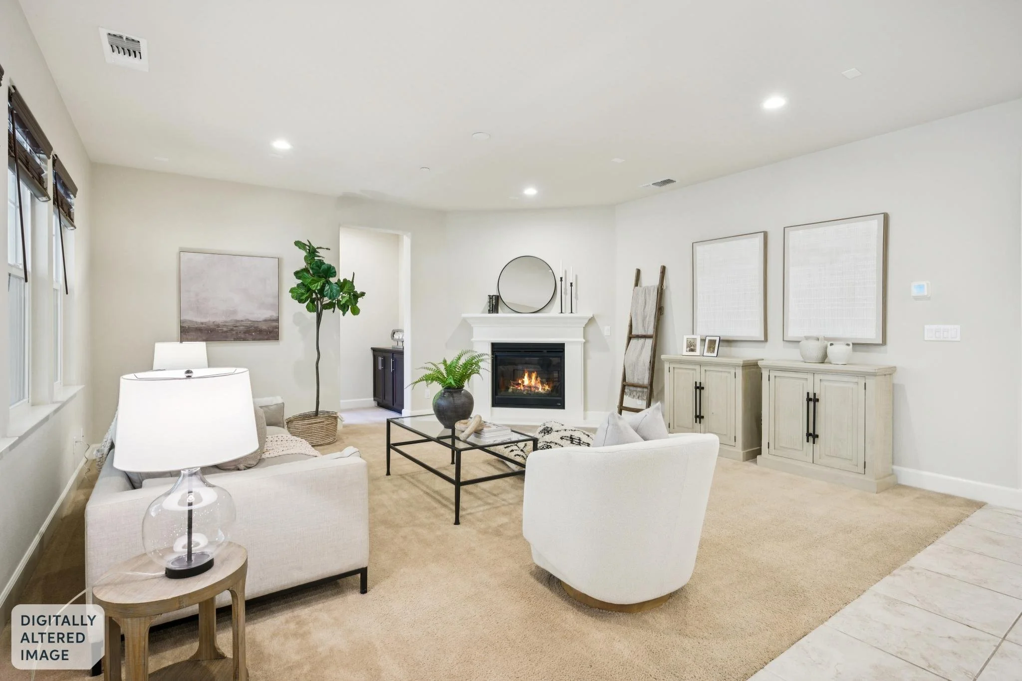Living room with white sofas, a black coffee table, floor lamp, fireplace, potted plant, wall art, and a large mirror, all with natural light from windows.