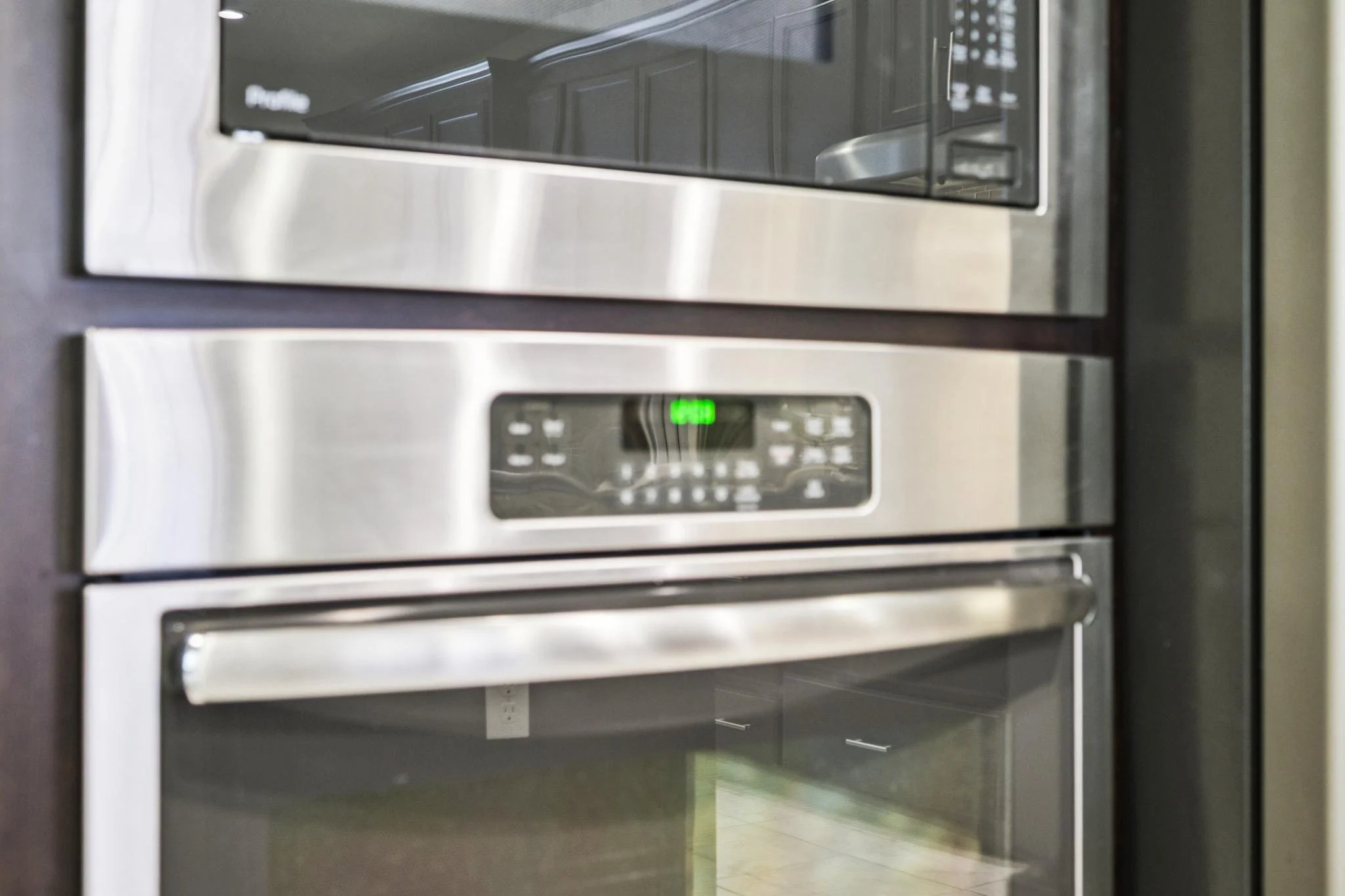 Stainless steel microwave oven built into kitchen cabinetry, digital display showing 4:59, and control panel with buttons.