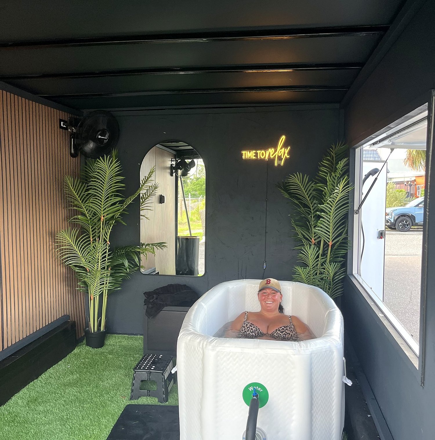 Guest smiling in a cold plunge inside the Suncoast Recovery mobile trailer at a private event in Tampa
