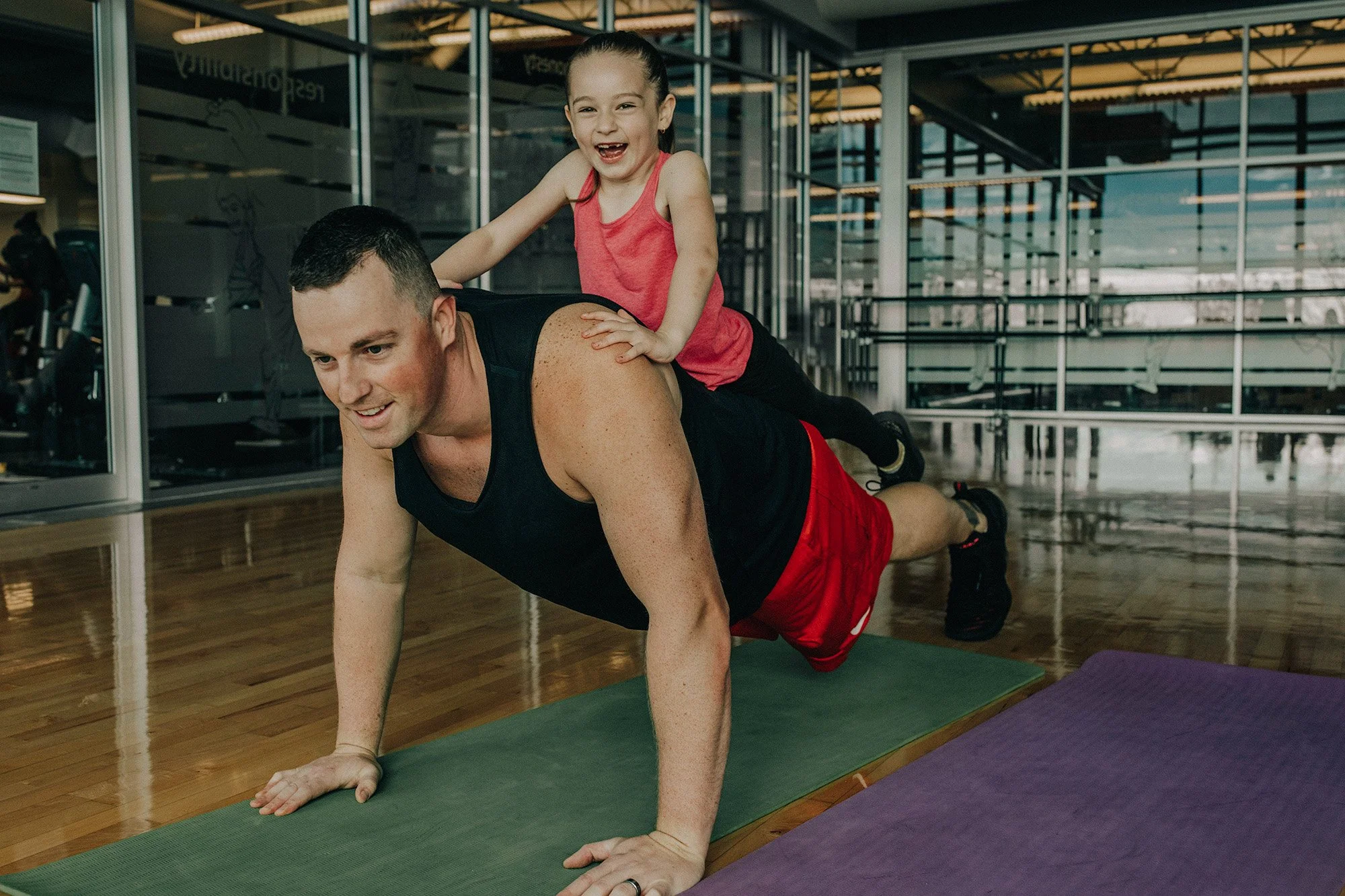 Dad and daughter doing push-ups together on exercise mats