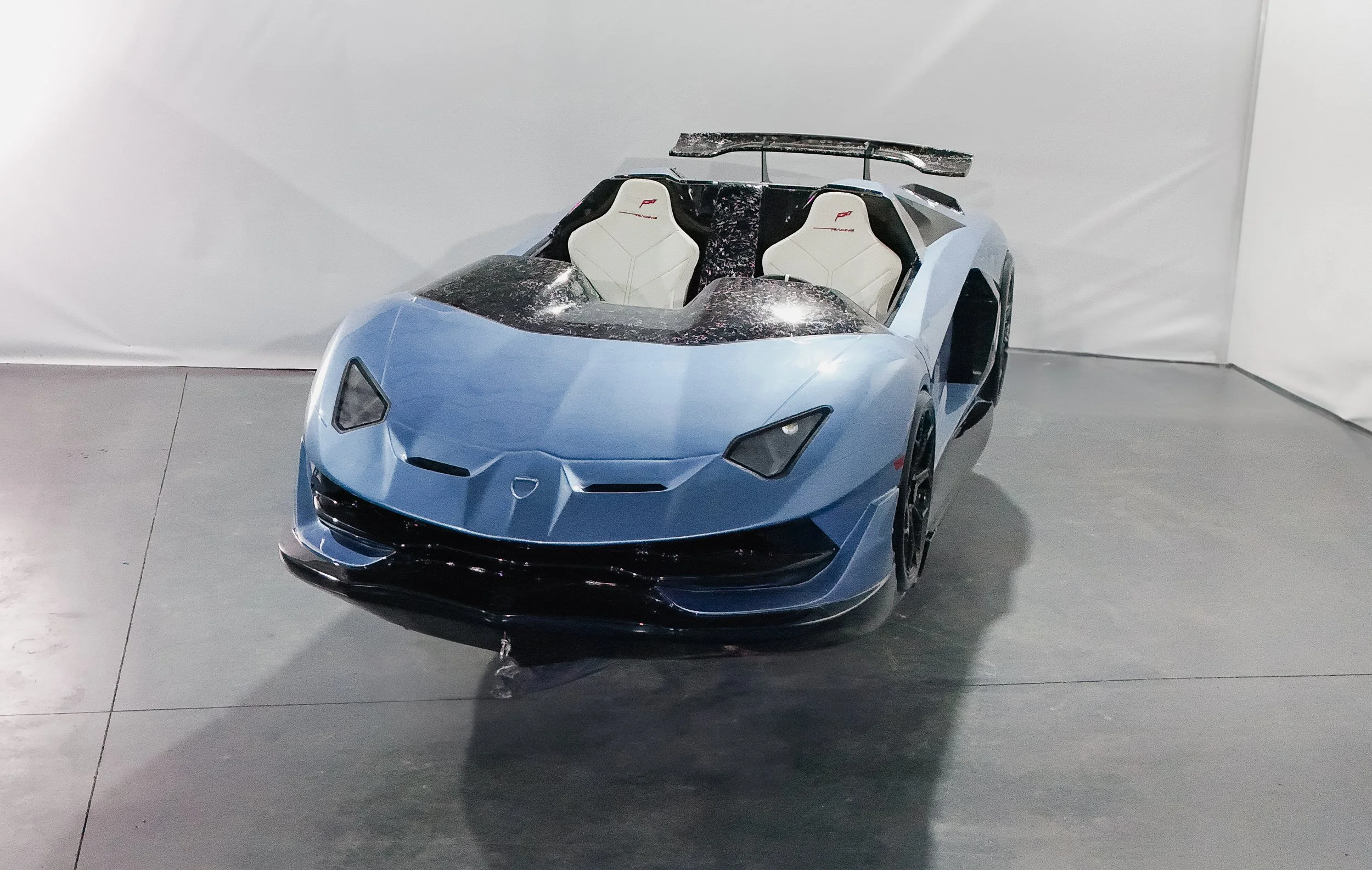 Tan Marine Syndicate luxury jet car in blue with white interior, featuring a futuristic cockpit design.