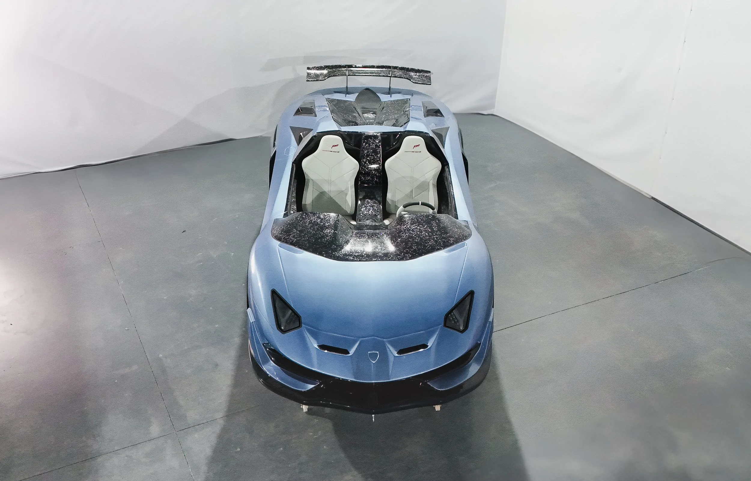 Blue and black Tan Marine Syndicate jet car, showcasing open cockpit design and premium racing seats, available for distribution in Canada