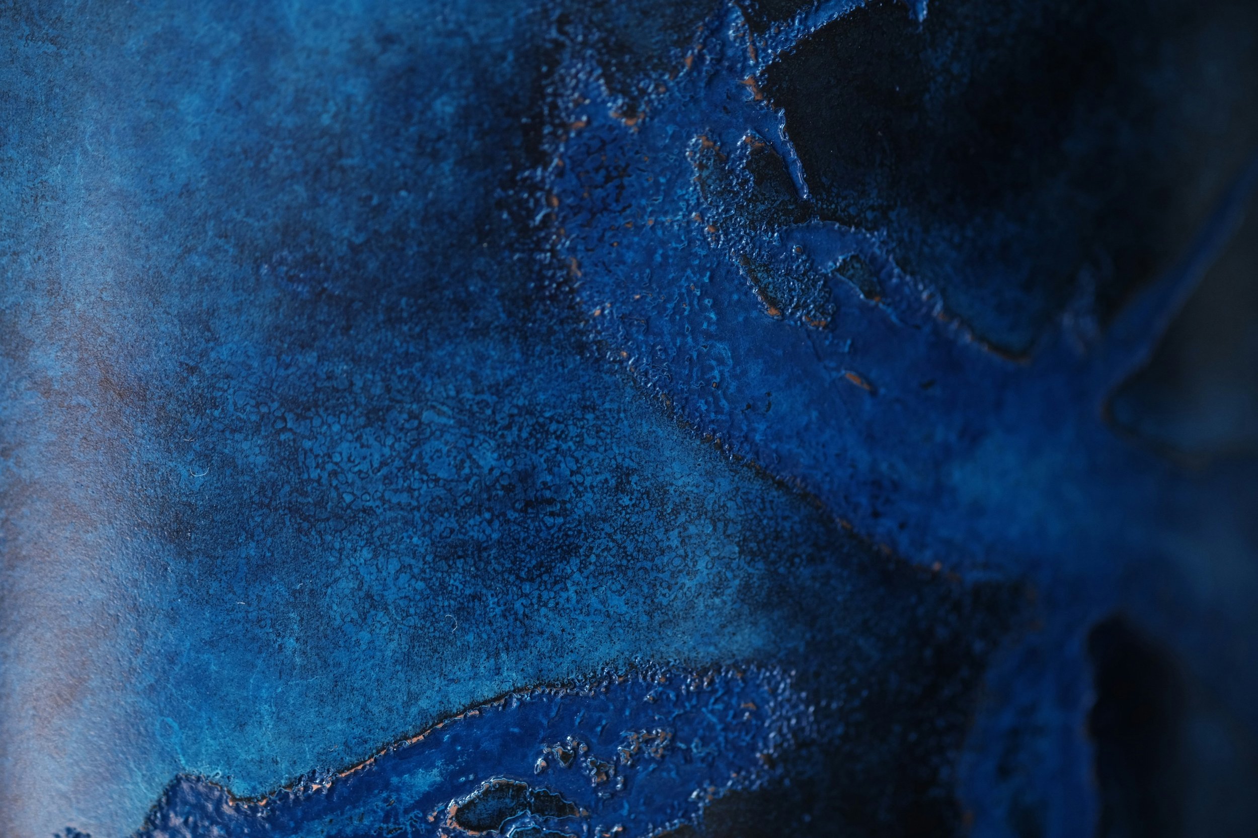 Nahaufnahme einer blauen, rostigen Metalloberfläche mit Rissen und Texturen.
