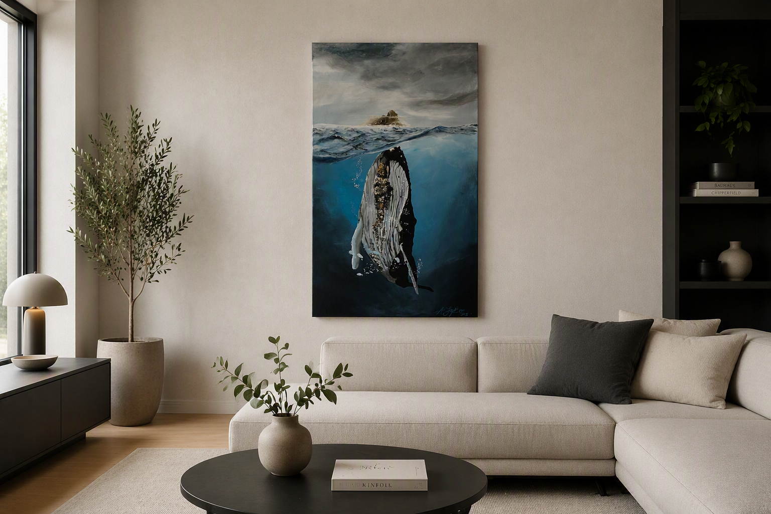 Modernes Wohnzimmer mit weißem Sofa, schwarzen Kissen, Pflanzen, Wandkunst, einem Gemälde von Anne Jaybee Art mit einem Buckelwal im Meer schwimmend und Schrank.