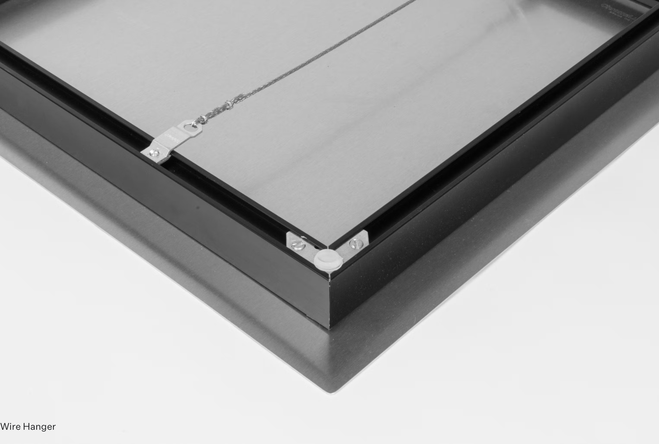 A wire hanger attached to the corner of a metallic frame, likely part of a display or appliance, with the words "Wire Hanger" in the bottom left corner.