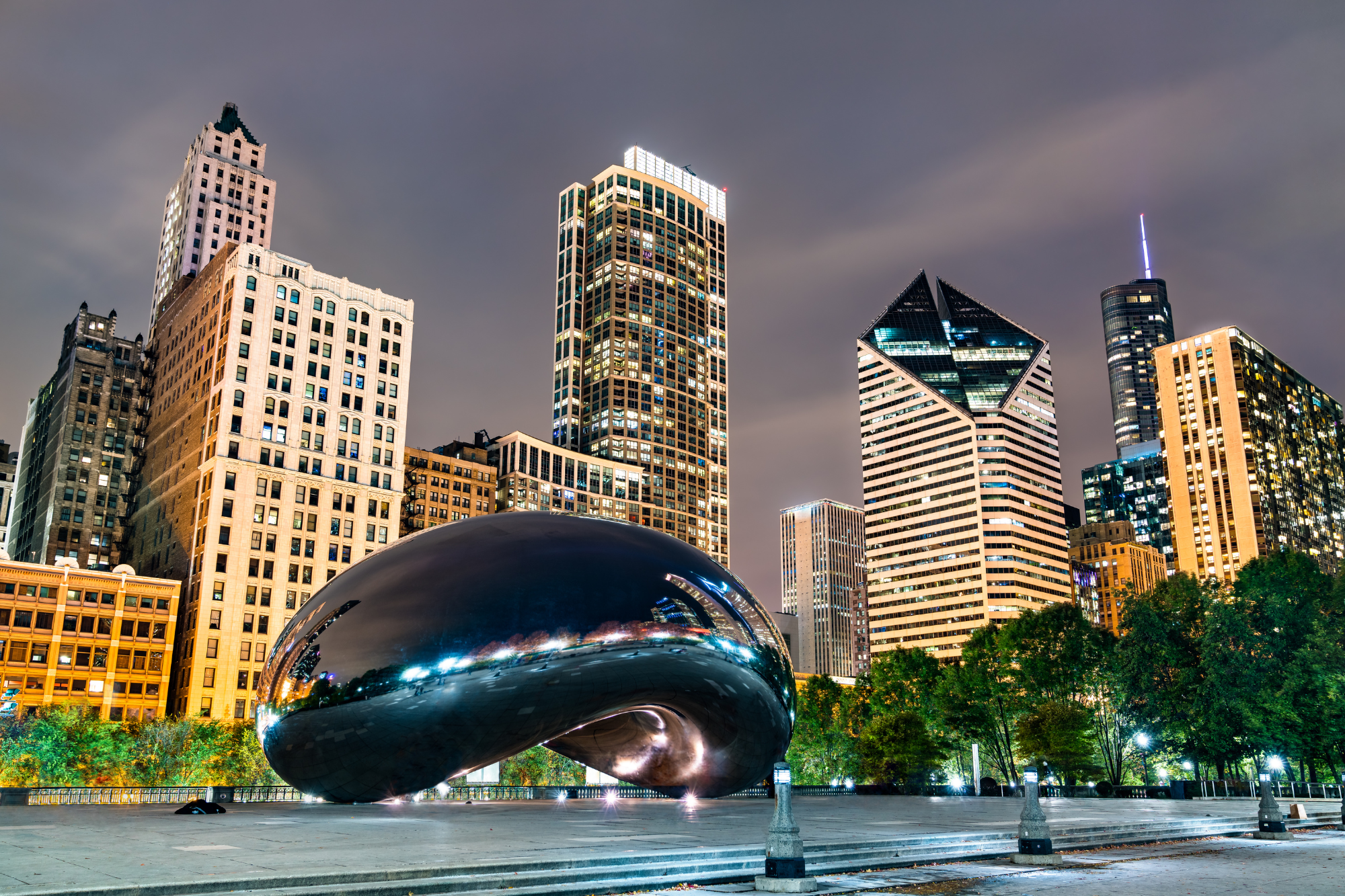 Night cityscape of downtown Chicago with skyscrapers, including the Cloud Gate sculpture, also known as The Bean, in Millennium Park.