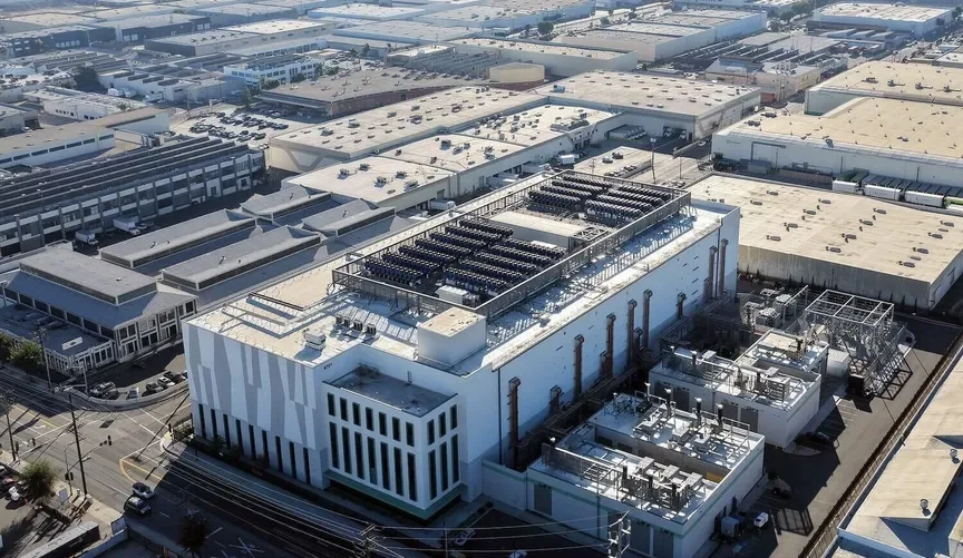 Aerial view of an industrial building with rooftop HVAC and cooling systems in a large industrial complex.