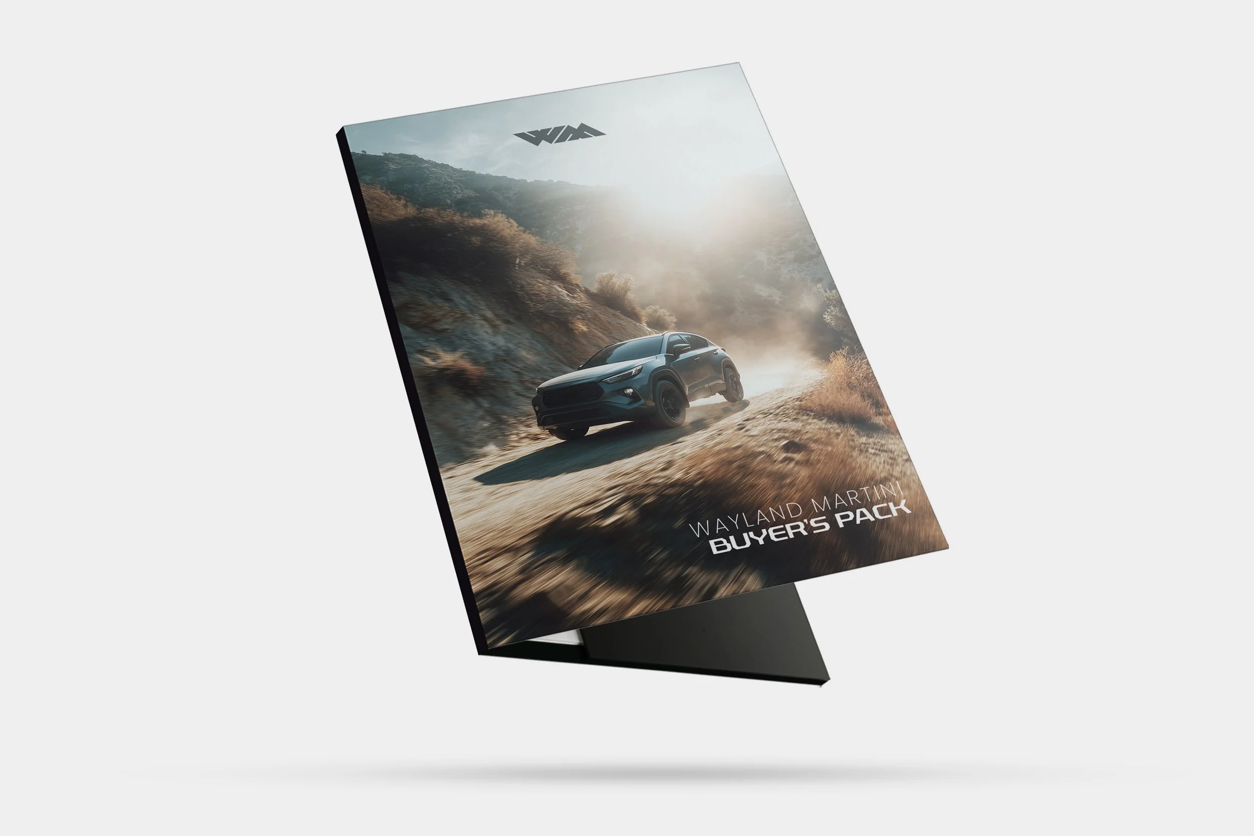 Brochure cover featuring a blue SUV driving on a dirt road in a hilly, dry landscape under a bright sky, with the text 'Wayland Martin Buyer's Pack'.
