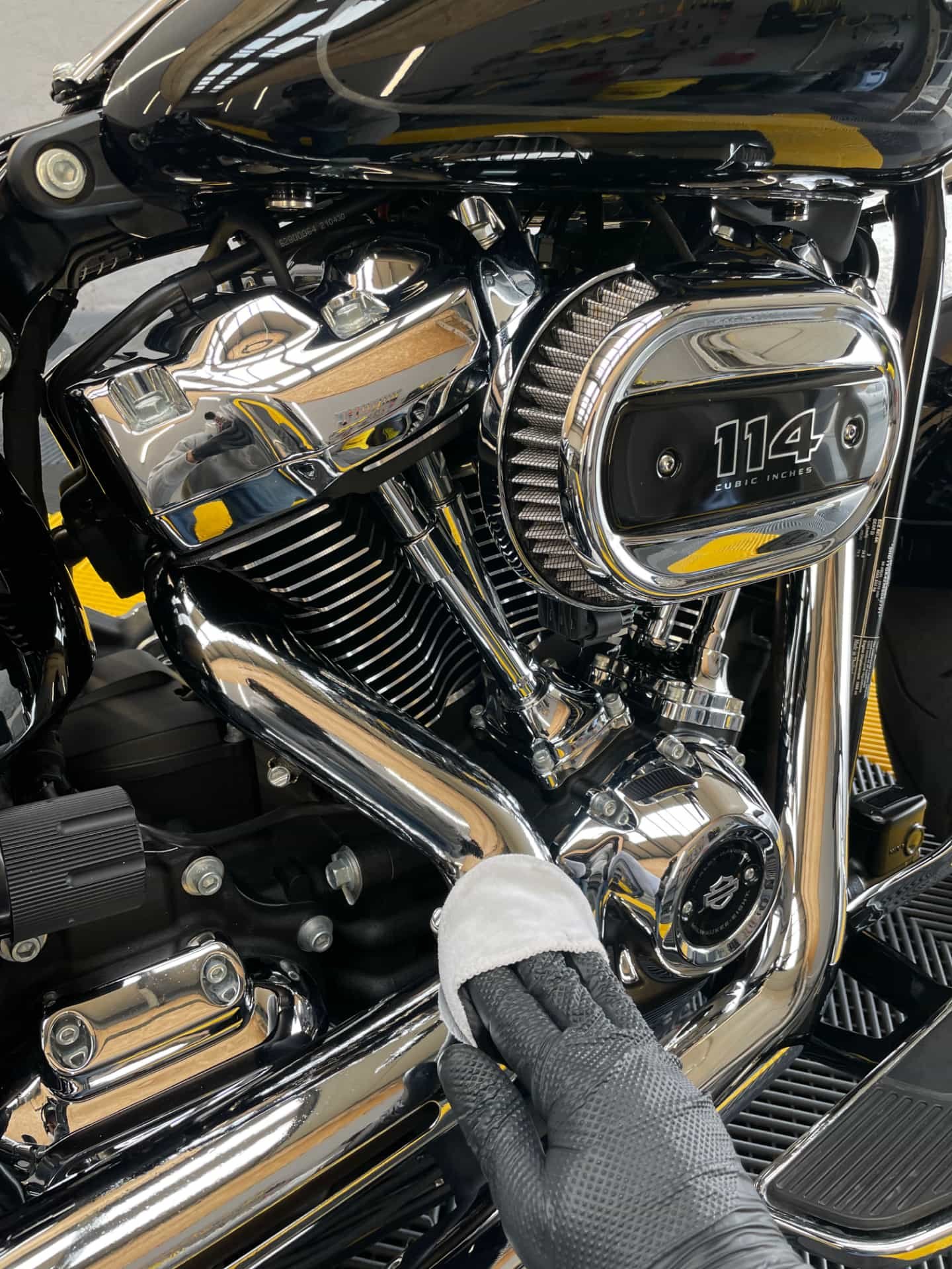 Détail d'une moto Harley-Davidson avec un moteur de 114 pouces cubes, montrant des composants en chrome et en métal.