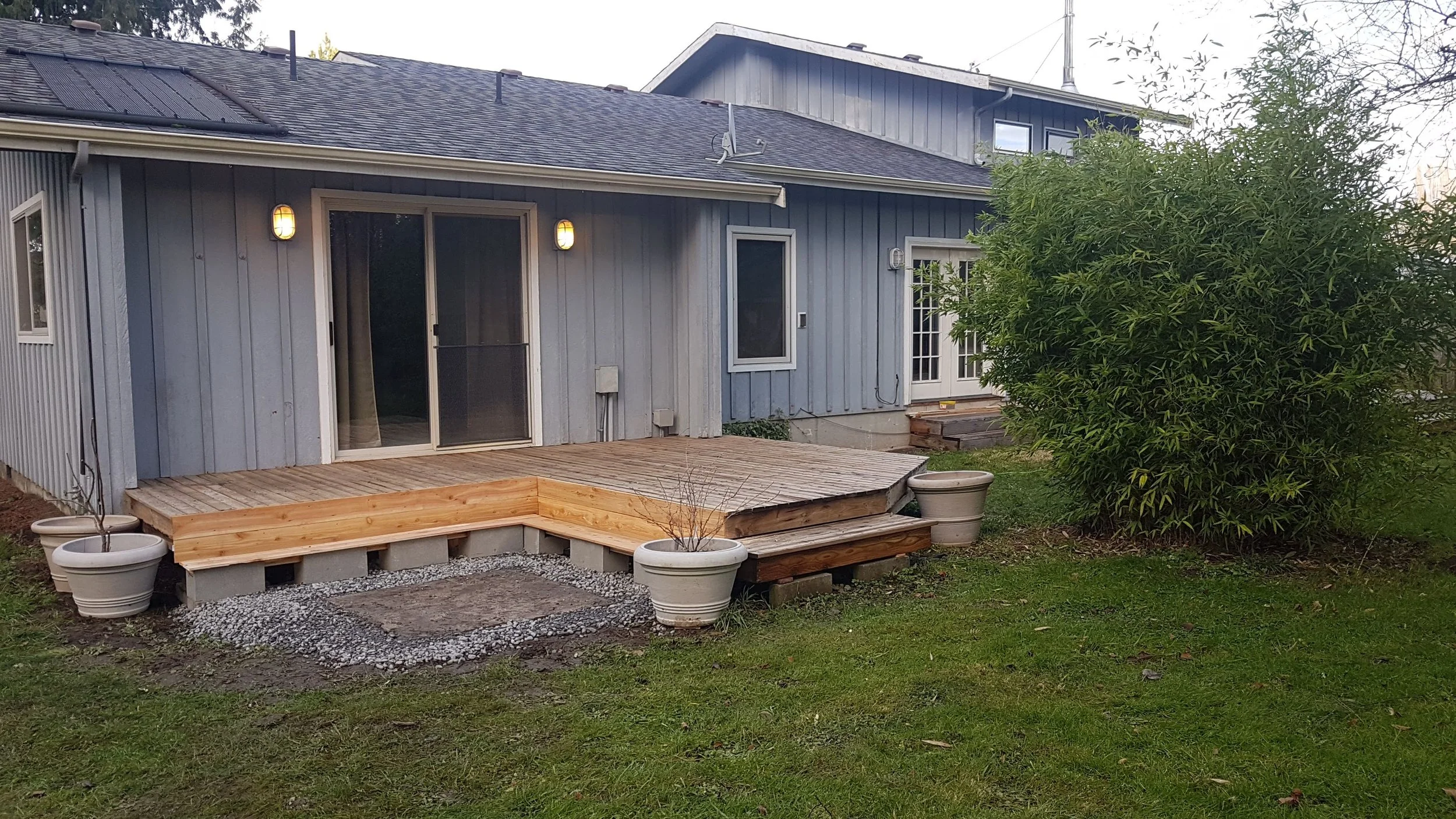 Backyard of a house with a freshly repaired wooden deck.