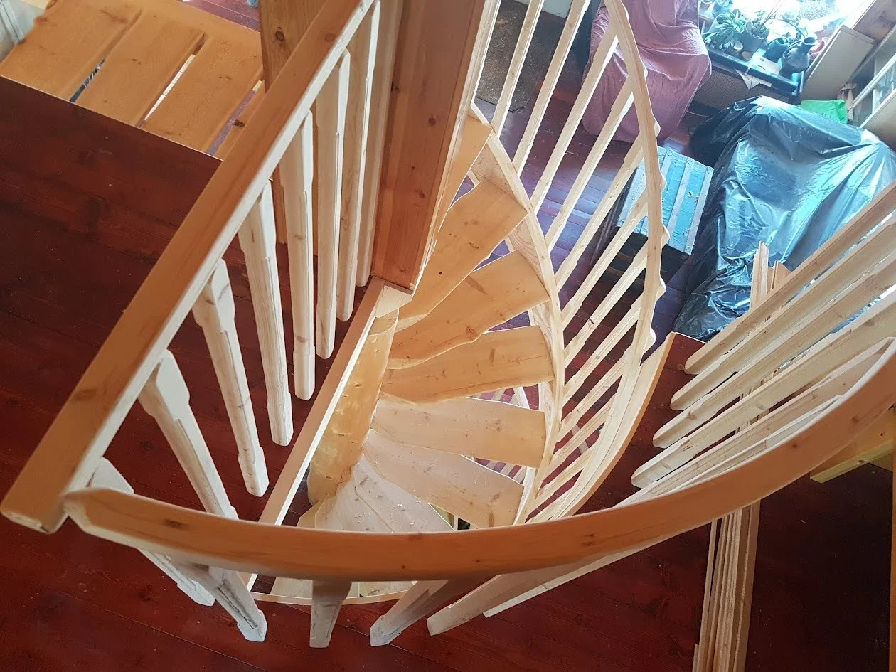 Wooden spiral staircase in a log home home interior.