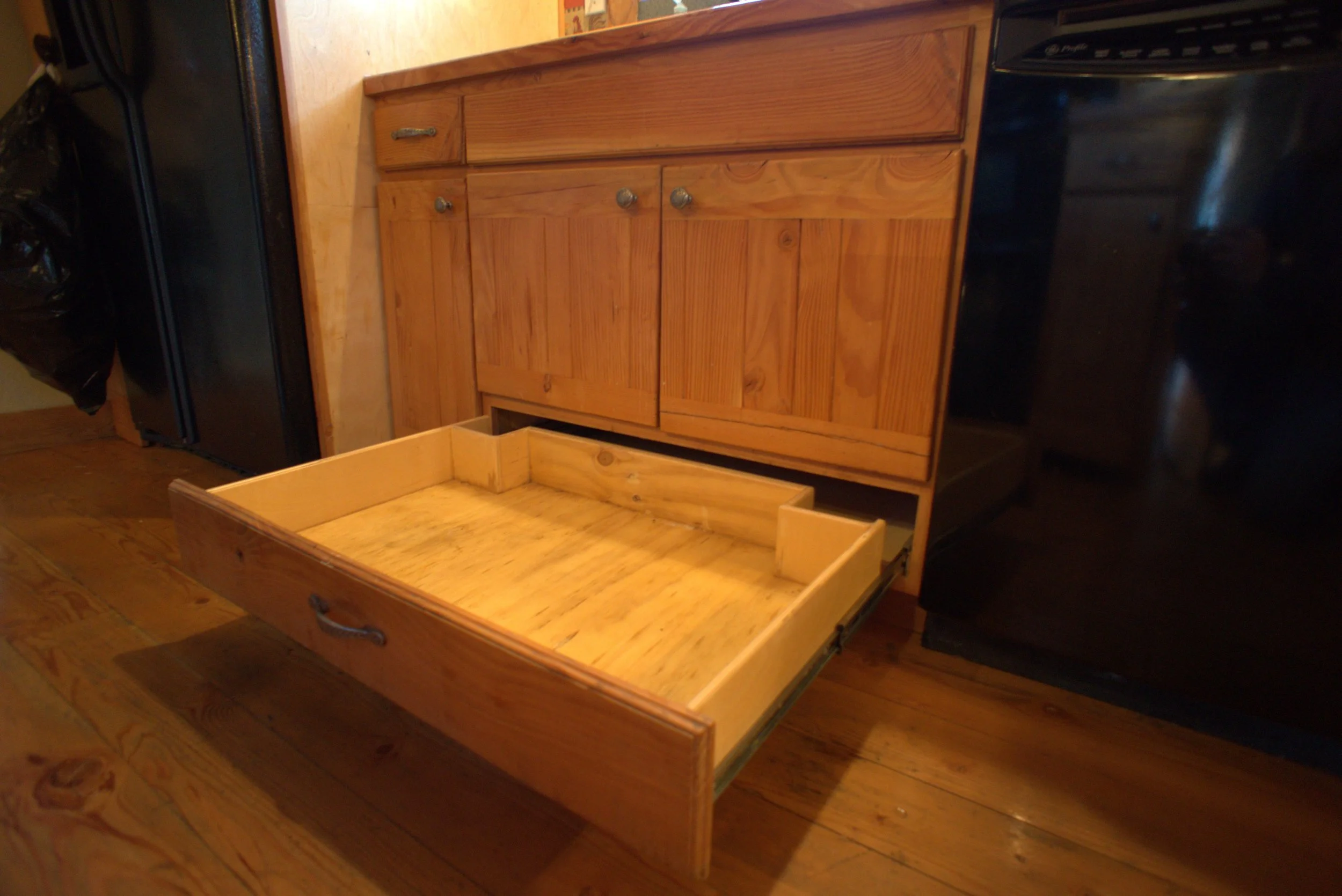 Drawer Below Kitchen Sink With Slide-Out Trash Behind Door Maximizes Space