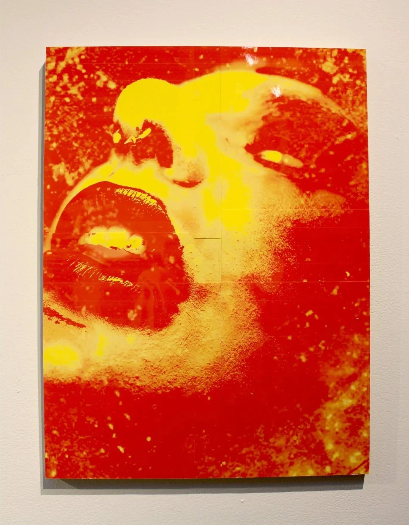 Close-up of a colorful, abstract portrait of a person's face with predominately red, yellow, and orange tones.