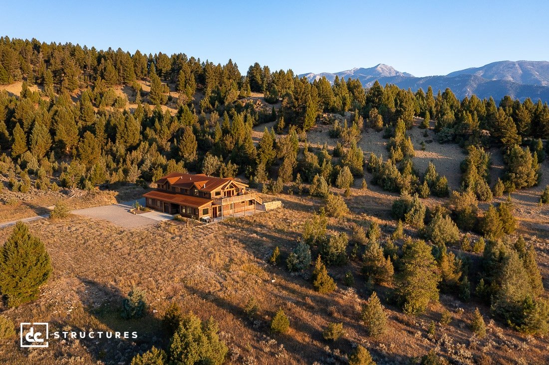 A wood-framed home situated in the middle of a forest in Big Sky, Montana.