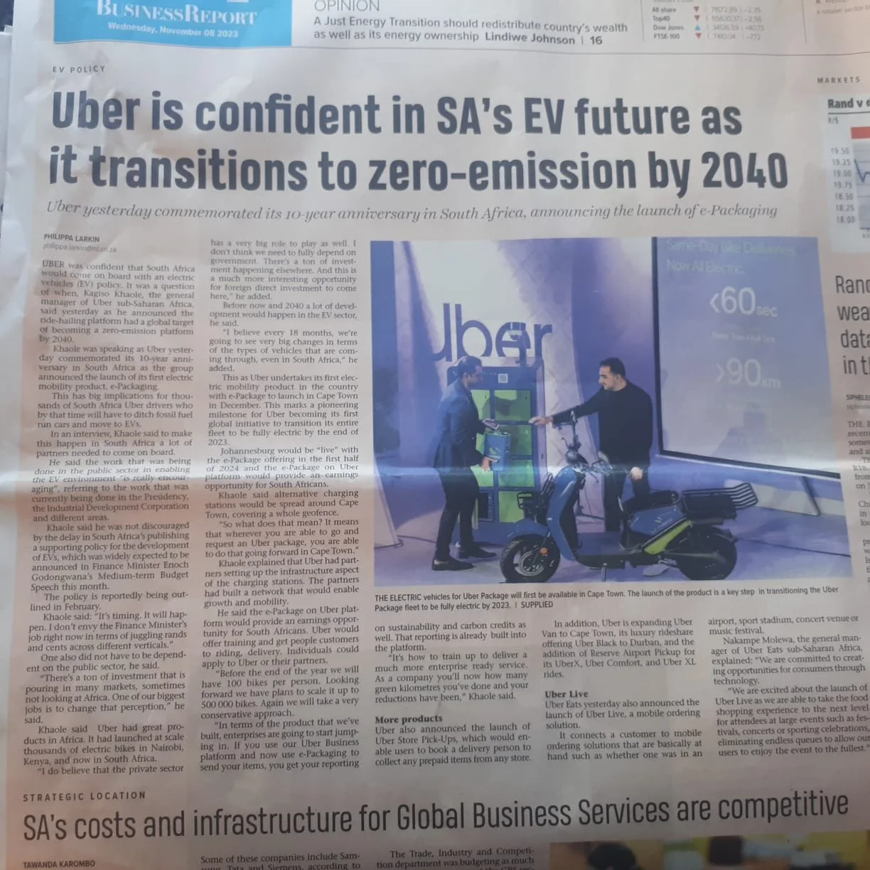 Newspaper article titled 'Uber is confident in SA's EV future as it transitions to zero-emission by 2040', with accompanying image of a man riding an electric scooter towards a charging station, symbolizing electric vehicle adoption in Cape Town.
