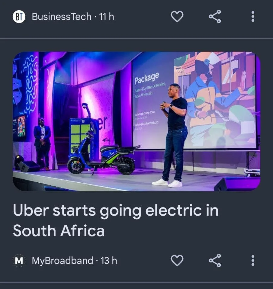 A man giving a presentation on stage at a conference, with a stylized digital illustration on a large screen, a blue and green electric scooter in the foreground, and another person standing nearby in business attire.