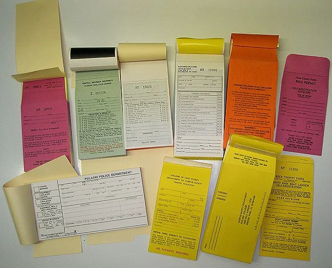 Custom printed parking citations and enforcement forms in assorted colors.