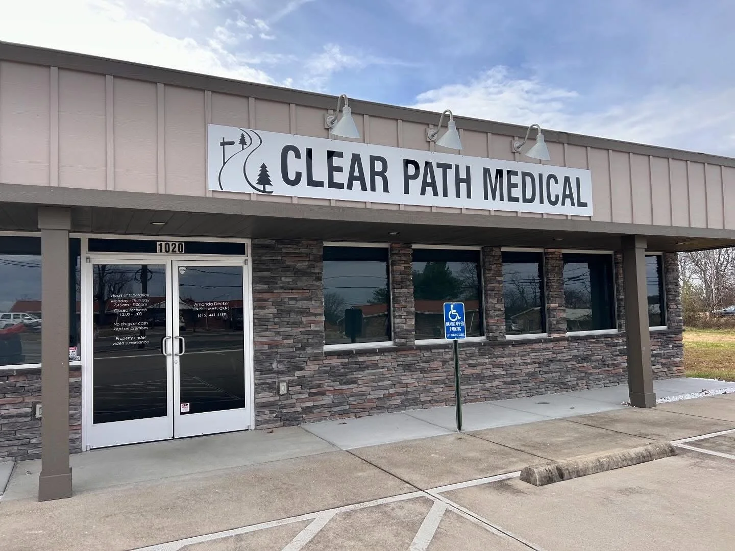 The exterior of Clear Path Medical clinic with a sign, glass doors, and a handicapped parking space.