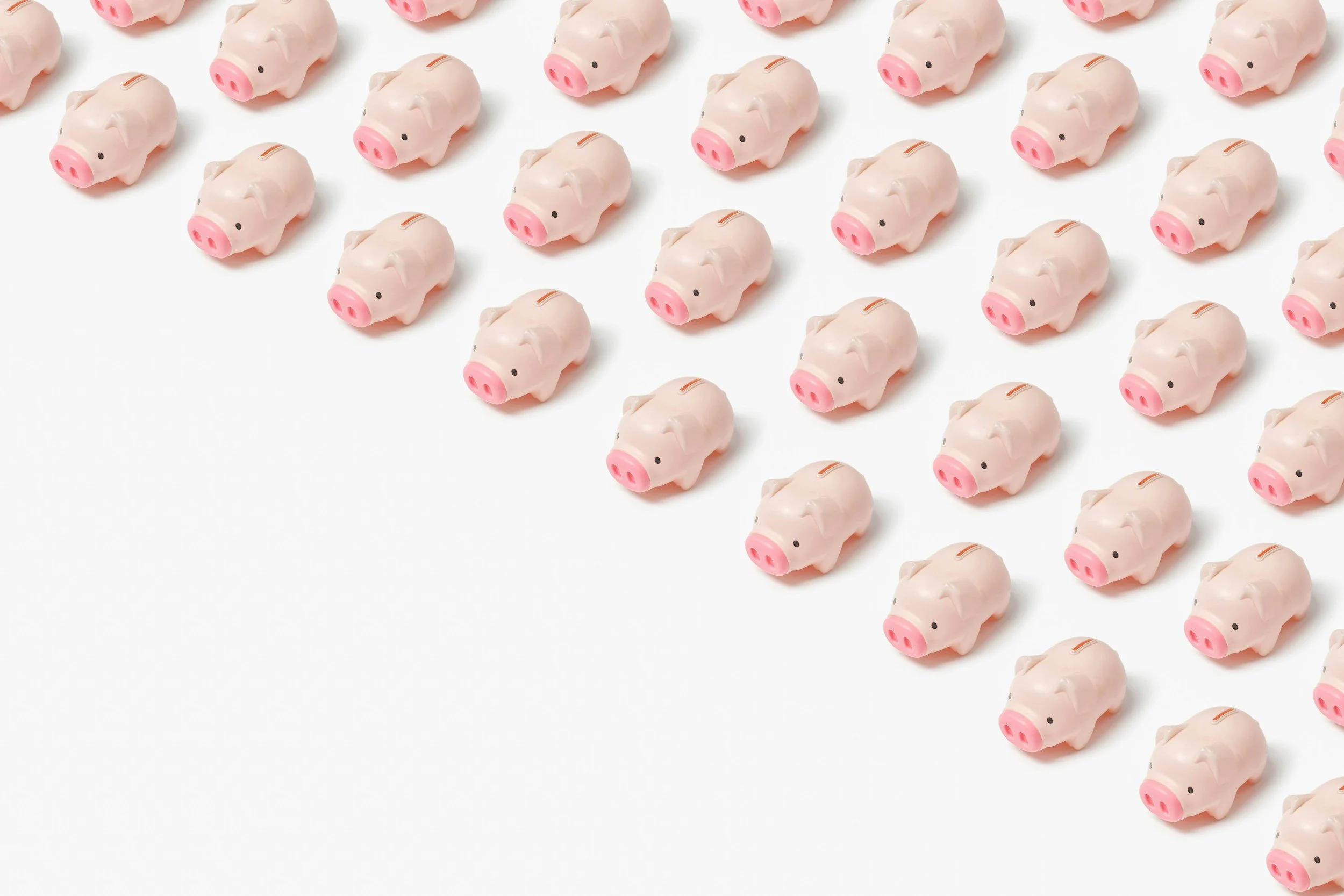 Multiple small pink piggy banks with black eyes and pink snouts, arranged in rows on a white surface.
