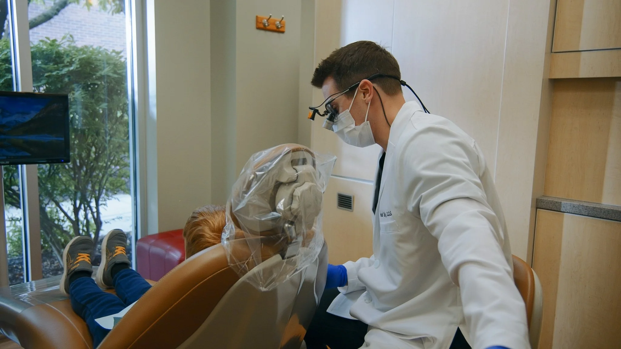A dentist performing a dental examination or procedure on a patient in a dental clinic.