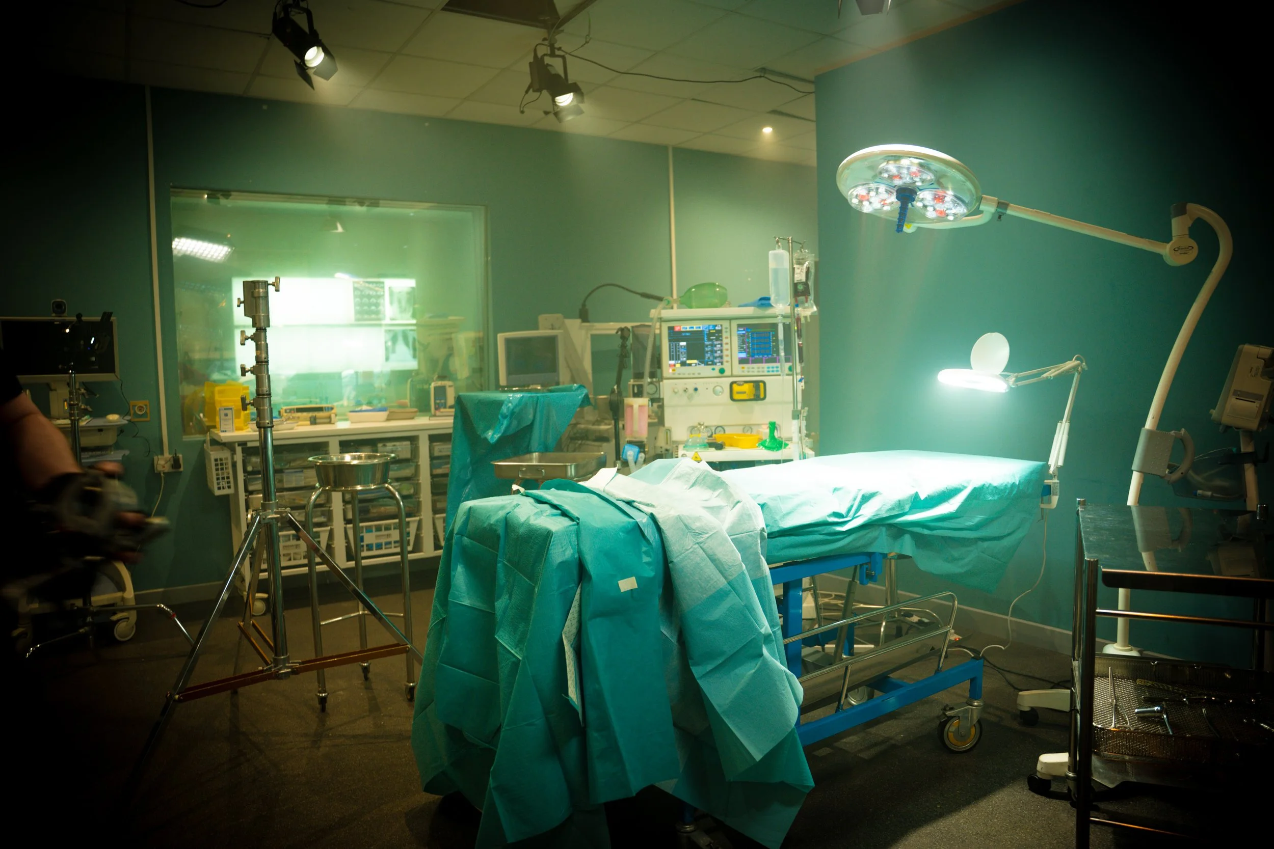 Operating room with surgical bed, medical equipment, and bright surgical lights