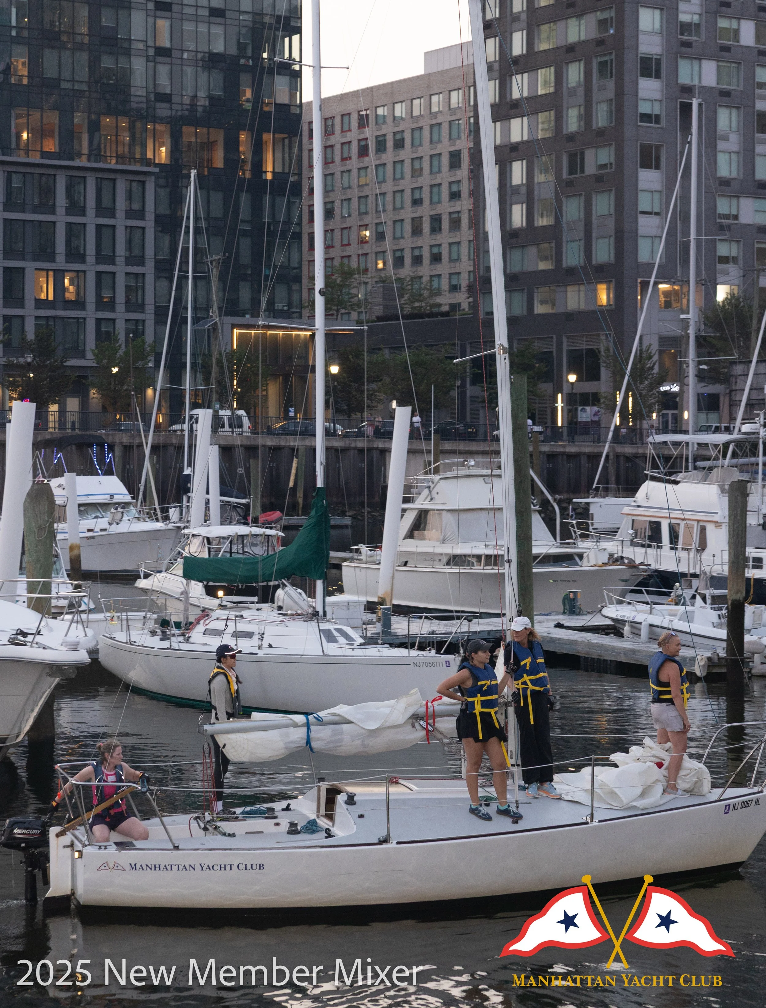 A corporate event professional photo of people preparing or participating in a boat event at a dock, with sailboats and tall modern buildings in the background, nighttime setting, and the logo of Manhattan Yacht Club.
