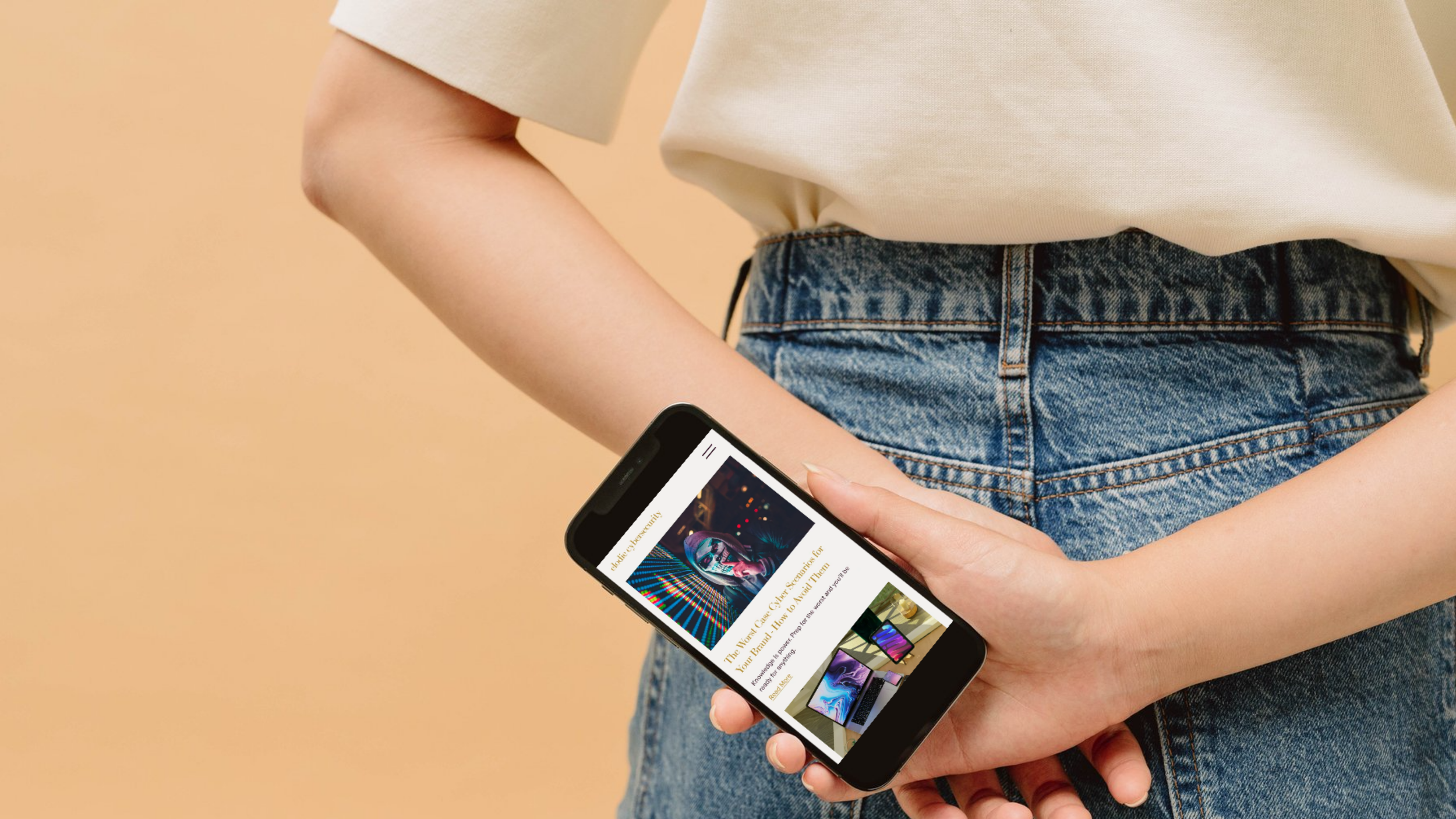 Person holding a smartphone displaying a webpage, wearing a beige T-shirt and blue jeans, with a solid beige background.