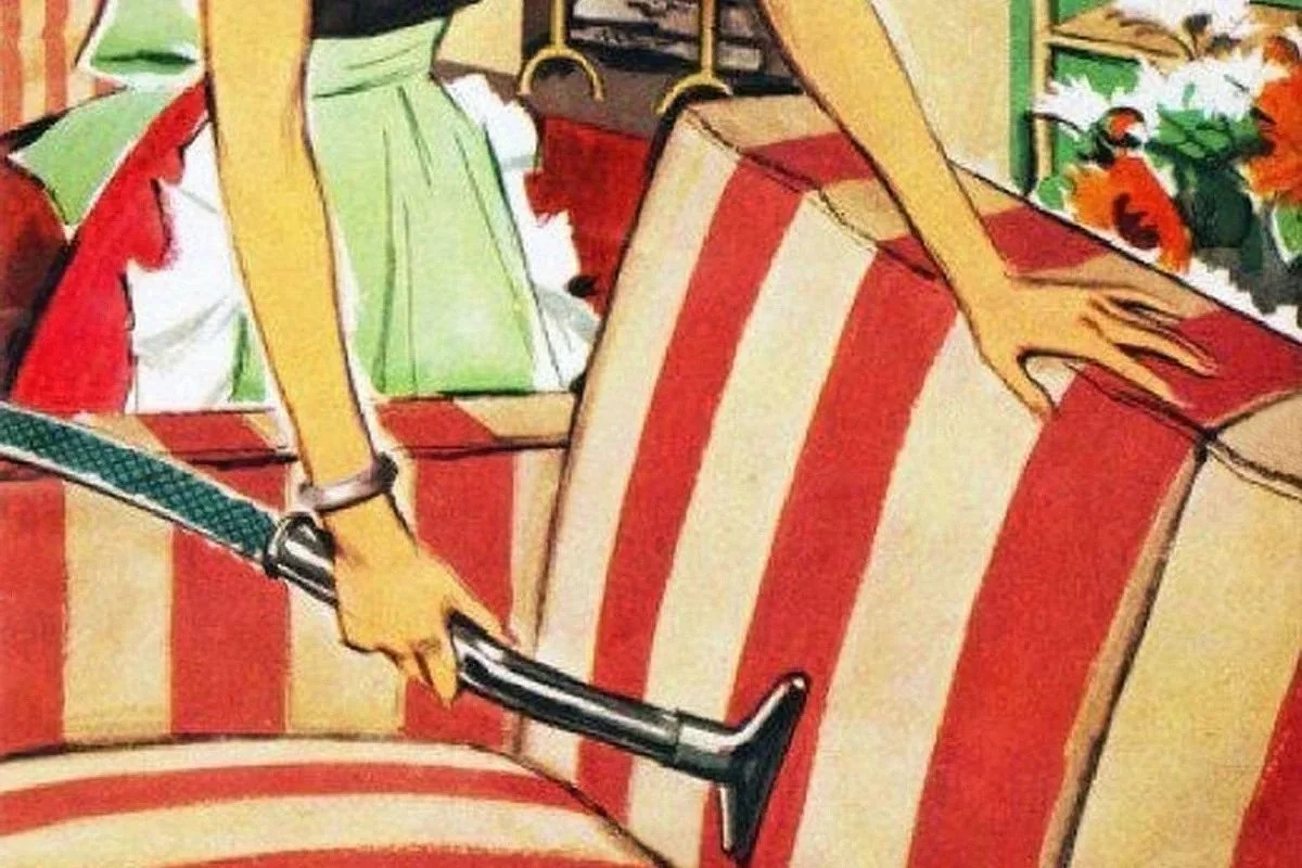 A woman using a vacuum cleaner.
