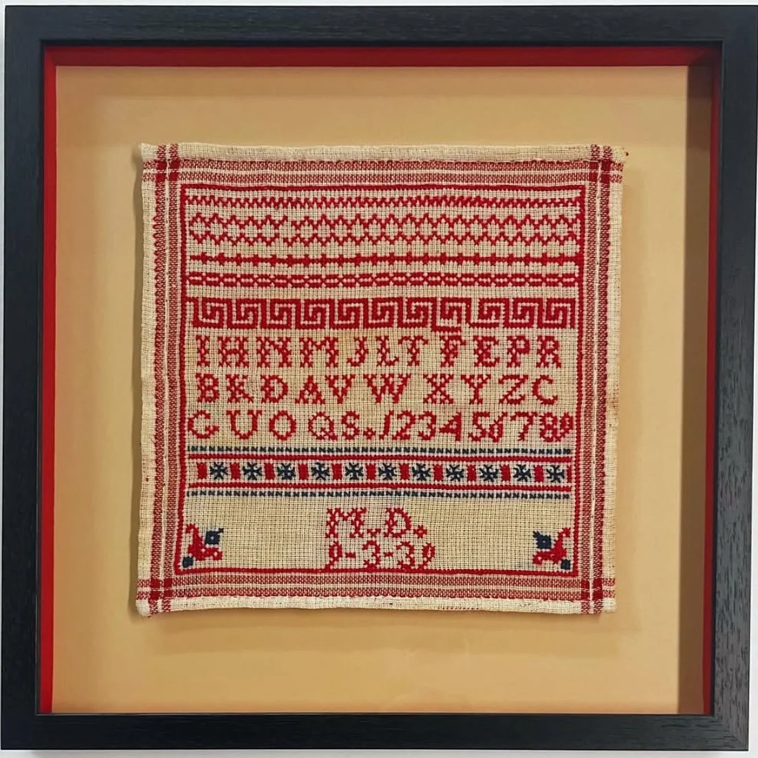 Vintage red and blue cross stitch sampler in floater frame