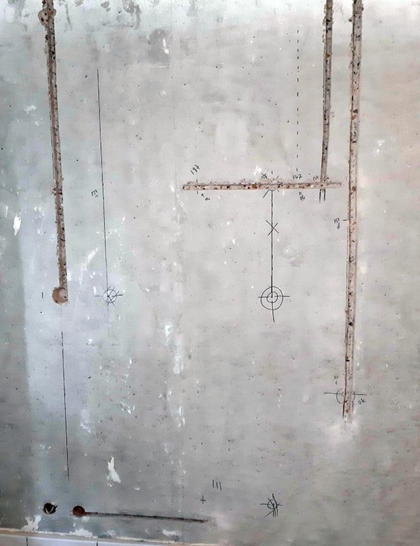 Une photo montrant des saignées pratiquées dans un mur en béton