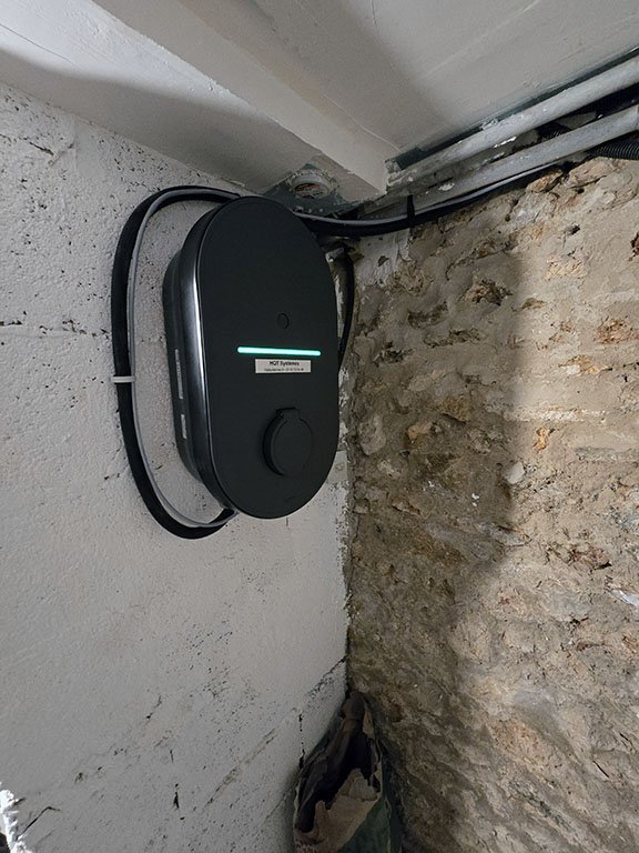photo d'une installation de borne de recharge dans une cave afin de préserver l'aspect extérieur de la maison. Utilisation d'un boitier de simulation TIC