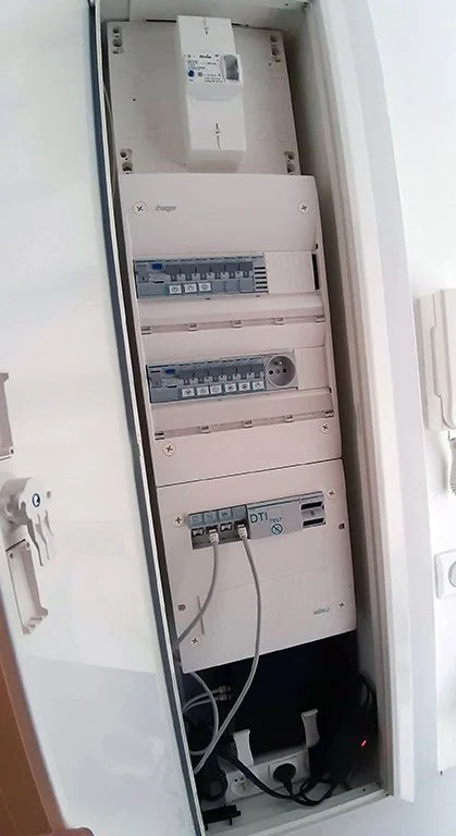 photo montrant le nouveau tableau, le coffret de communication et le disjoncteur de branchement intégrés dans une baie encastrée