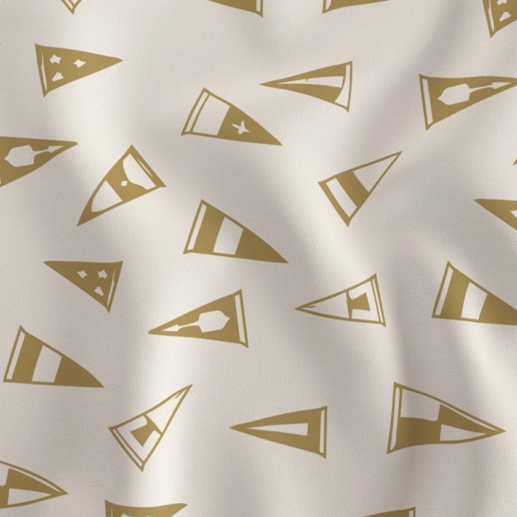 A fabric with a pattern of gold and white football helmets and pennants.