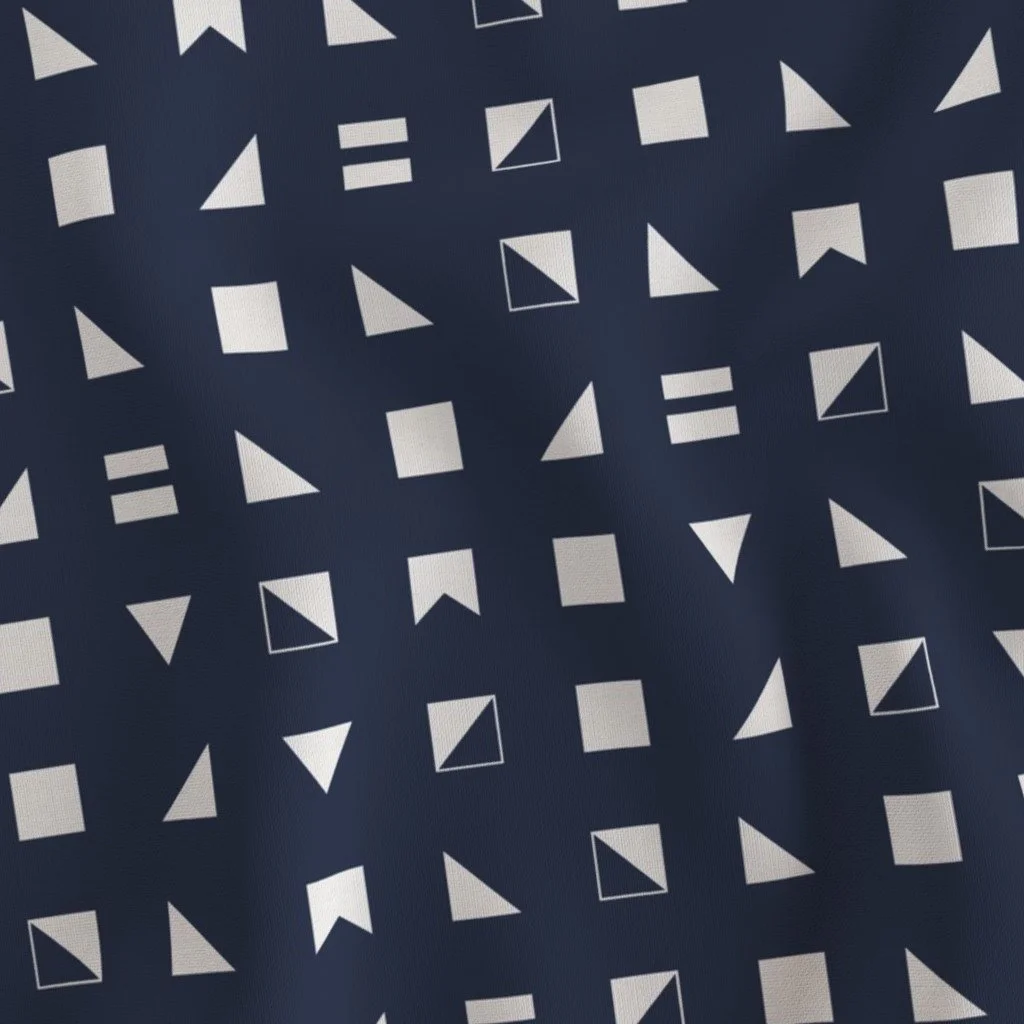 A fabric with a pattern of white geometric shapes including triangles, squares, and outlined triangles on a dark blue background.