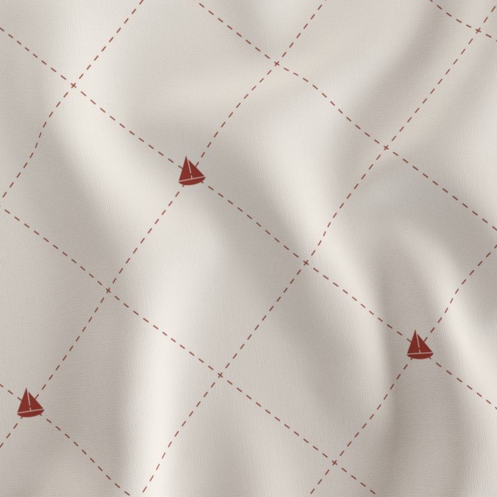 A close-up of a white fabric with a red grid pattern and small red sailboat illustrations at the intersections.
