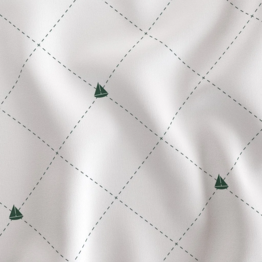 Close-up of white fabric with a grid pattern and small sailboat illustrations at some intersections.
