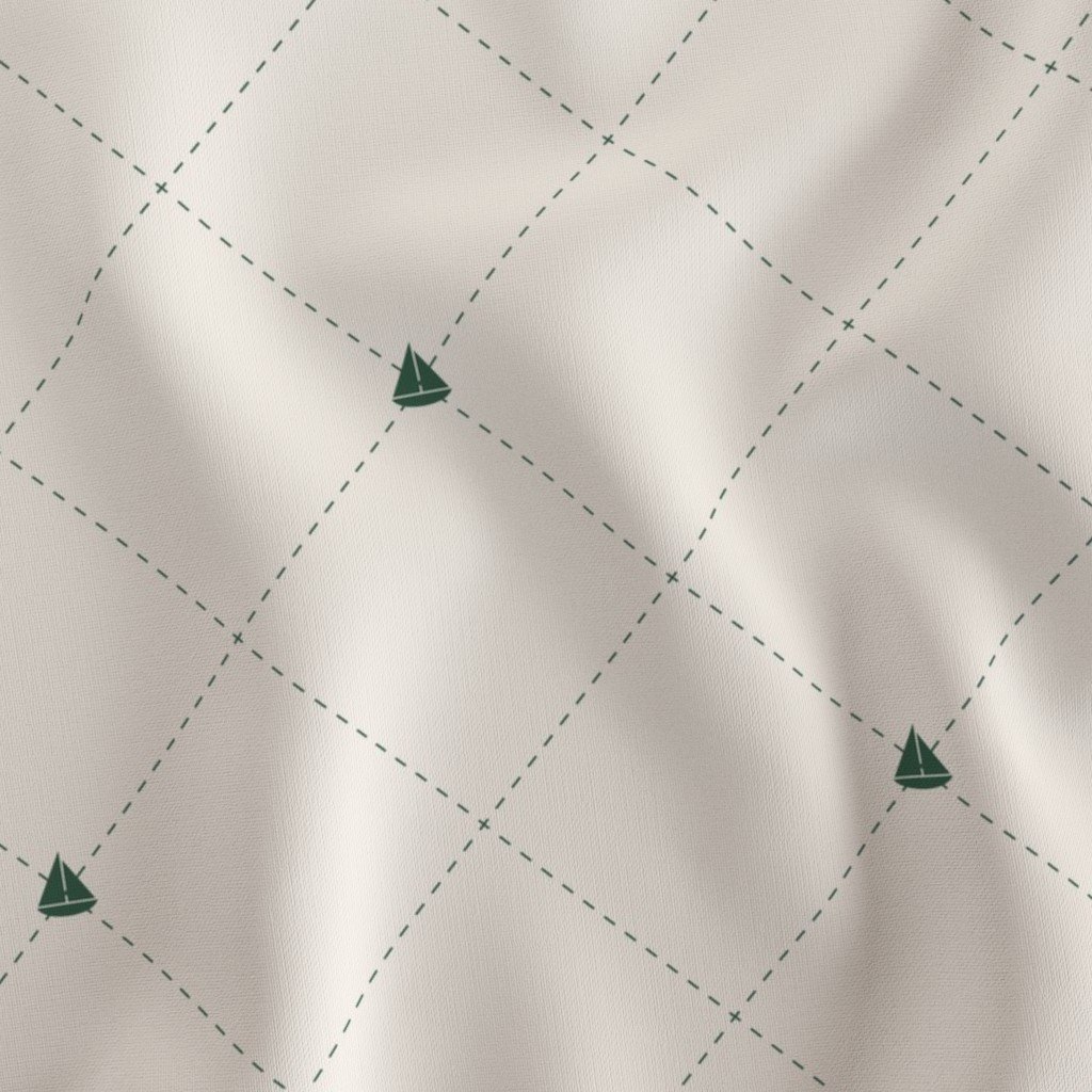 A white fabric with a green sailboat pattern and a diamond-shaped grid.