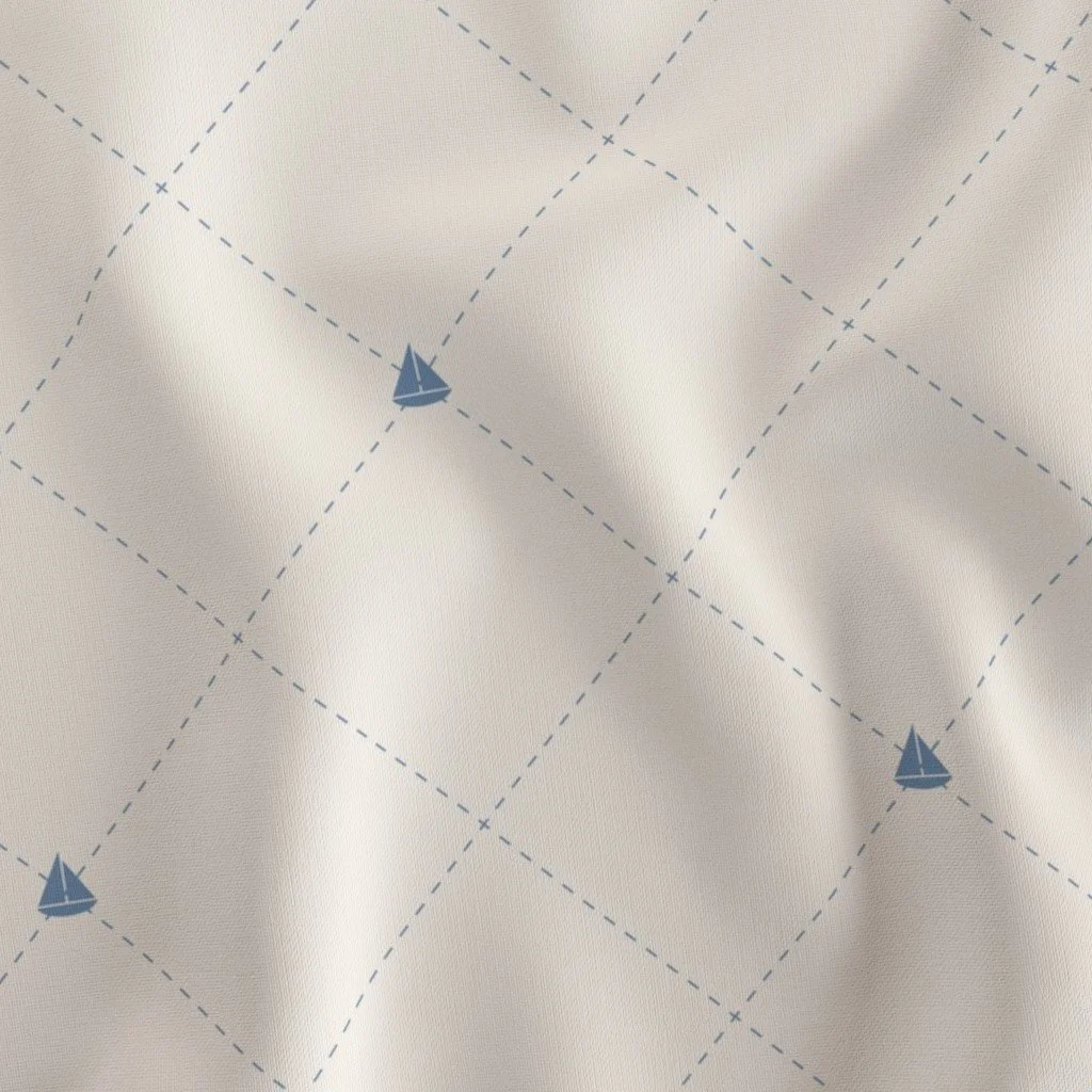 Close-up of fabric with a nautical pattern of blue sailboats and dashed lines in a diamond grid.
