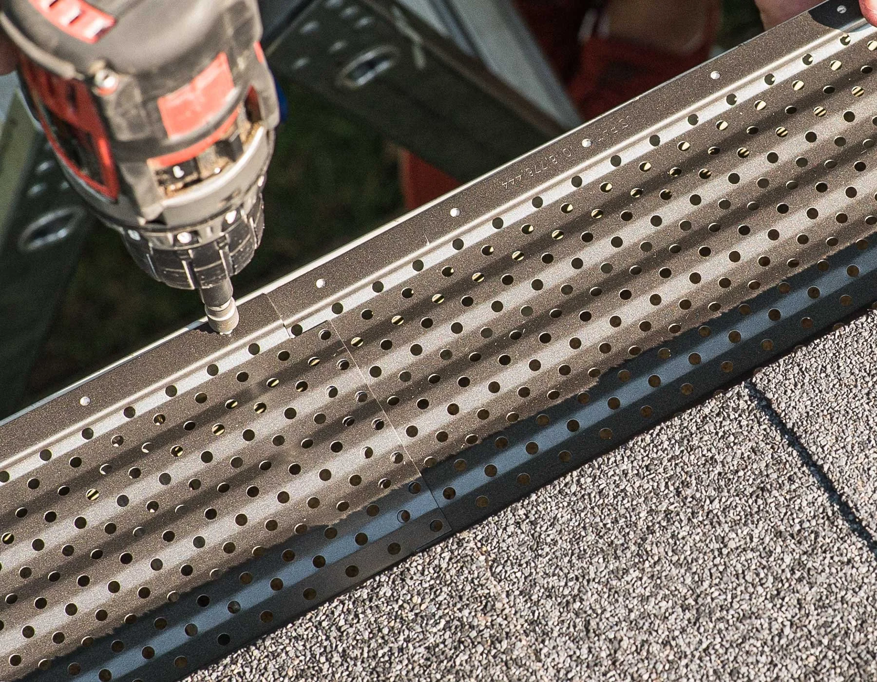 GutterRx Micro-Pore Filtration evacuates water through holes in the aluminum gutter cover.