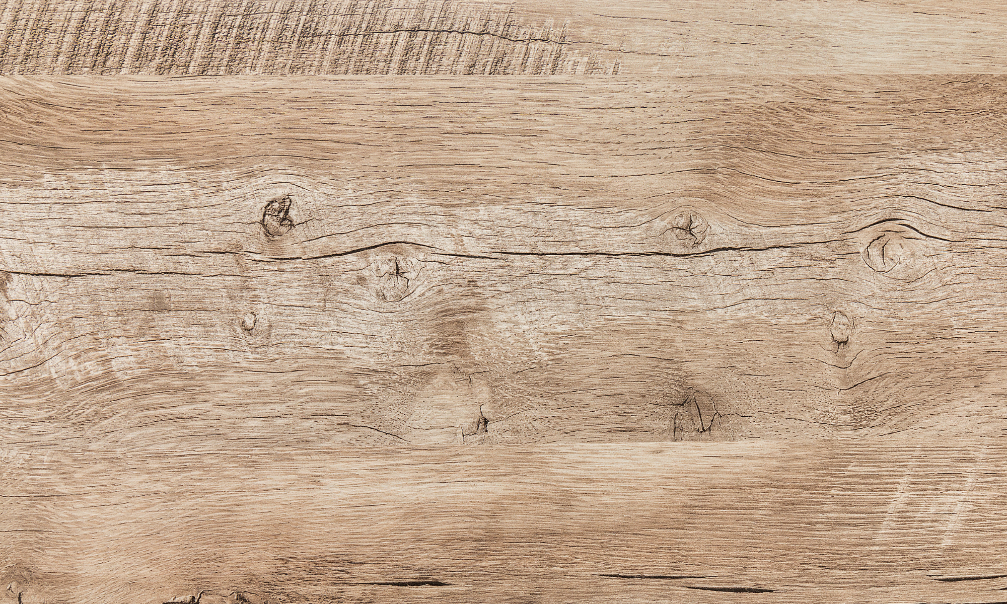 Close-up of a light brown wooden surface with visible grain, knots, and cracks.