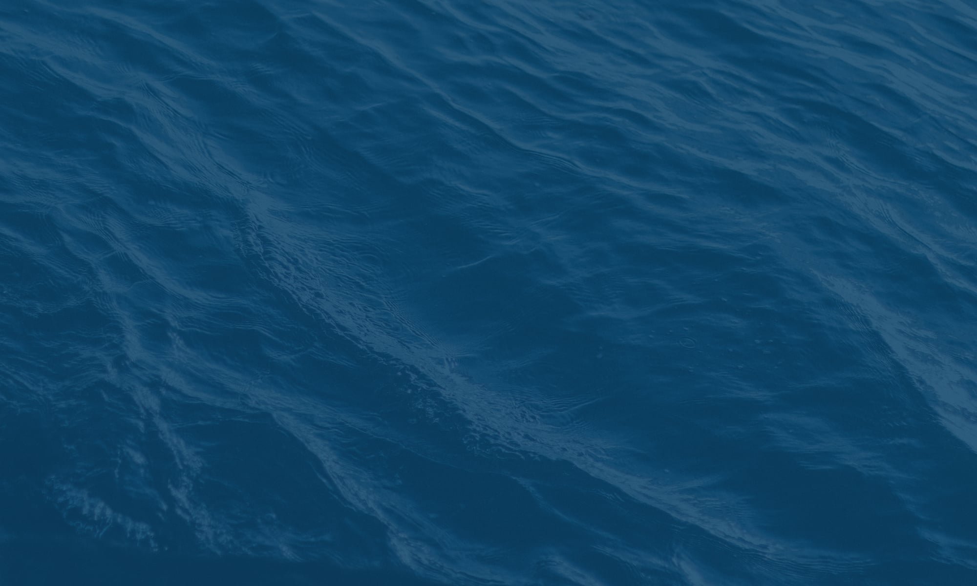 Open ocean water with small waves on the surface.
