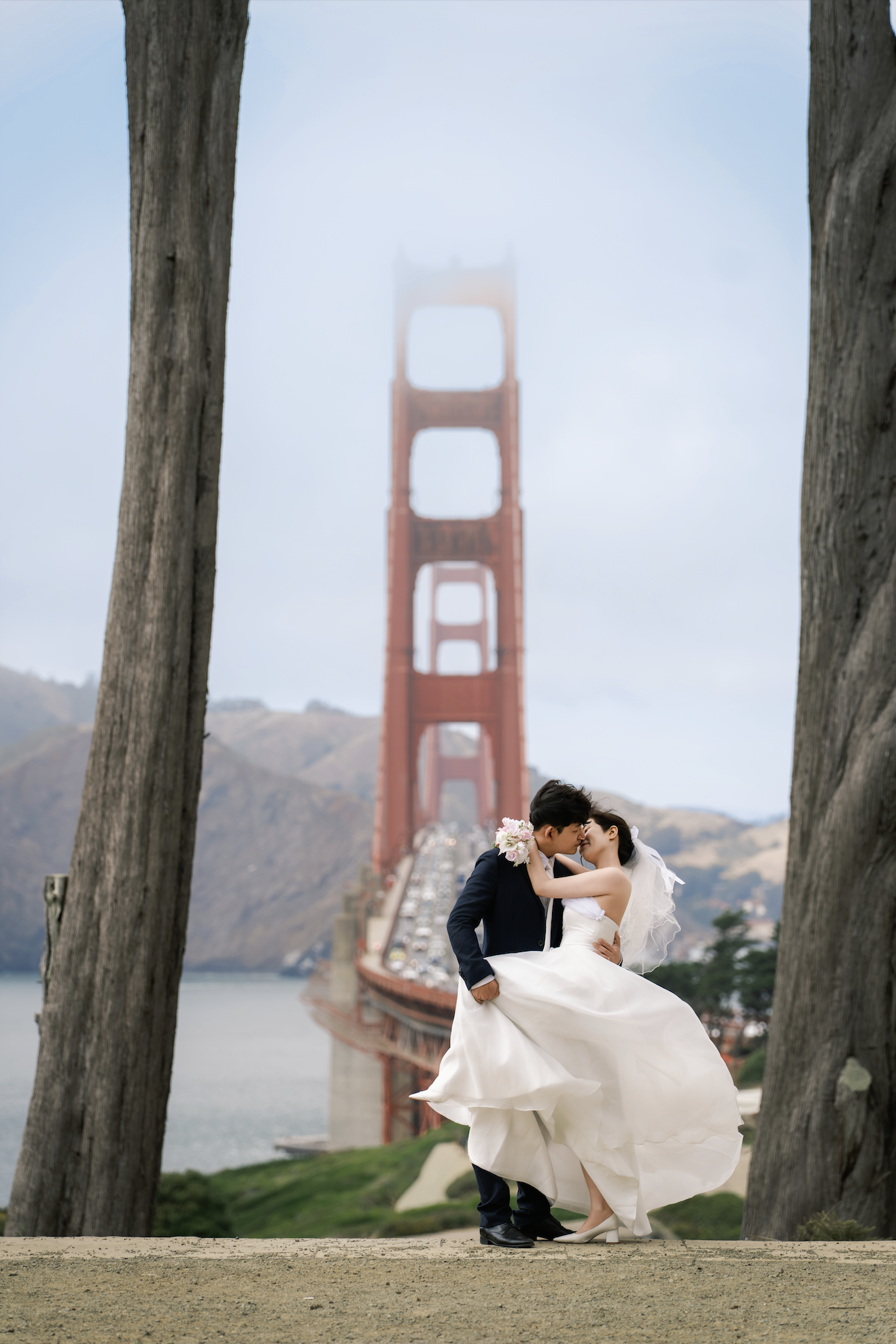 Couple kissing at sunset with the Golden Gate Bridge in San Francisco.