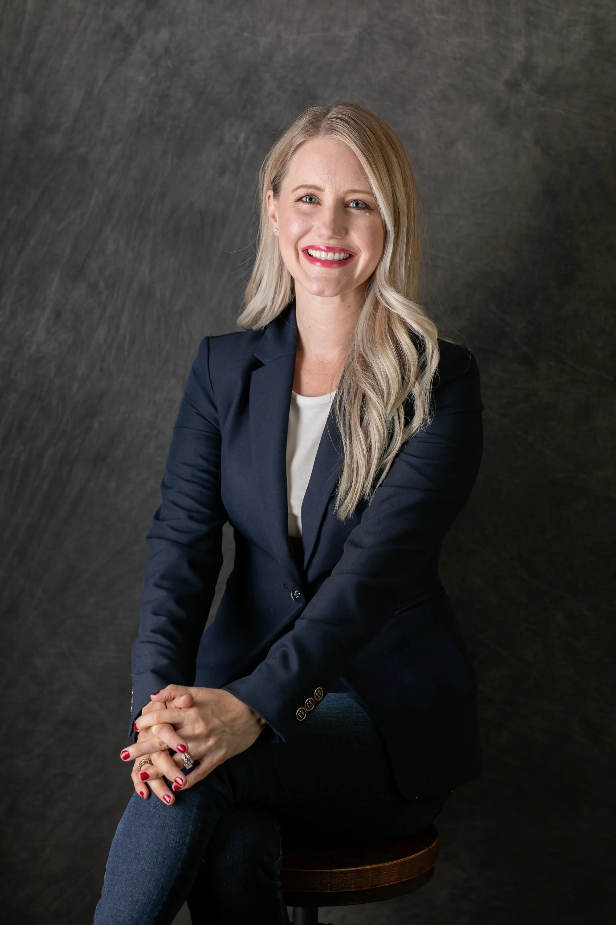 A smiling health psychologist with long blonde hair wearing a navy blue blazer.