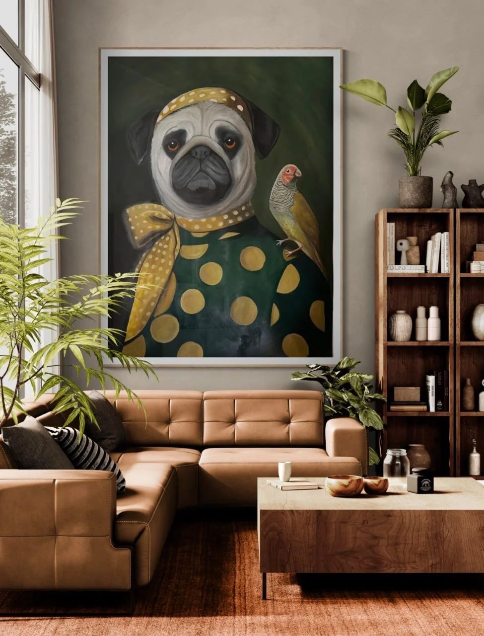 How a Suzan Jones painting would look in your Living room with a large framed portrait of a pug dressed in a polka dot outfit, accompanied by a bird, on the wall above a tan sectional sofa, with plants and a wooden bookshelf nearby.