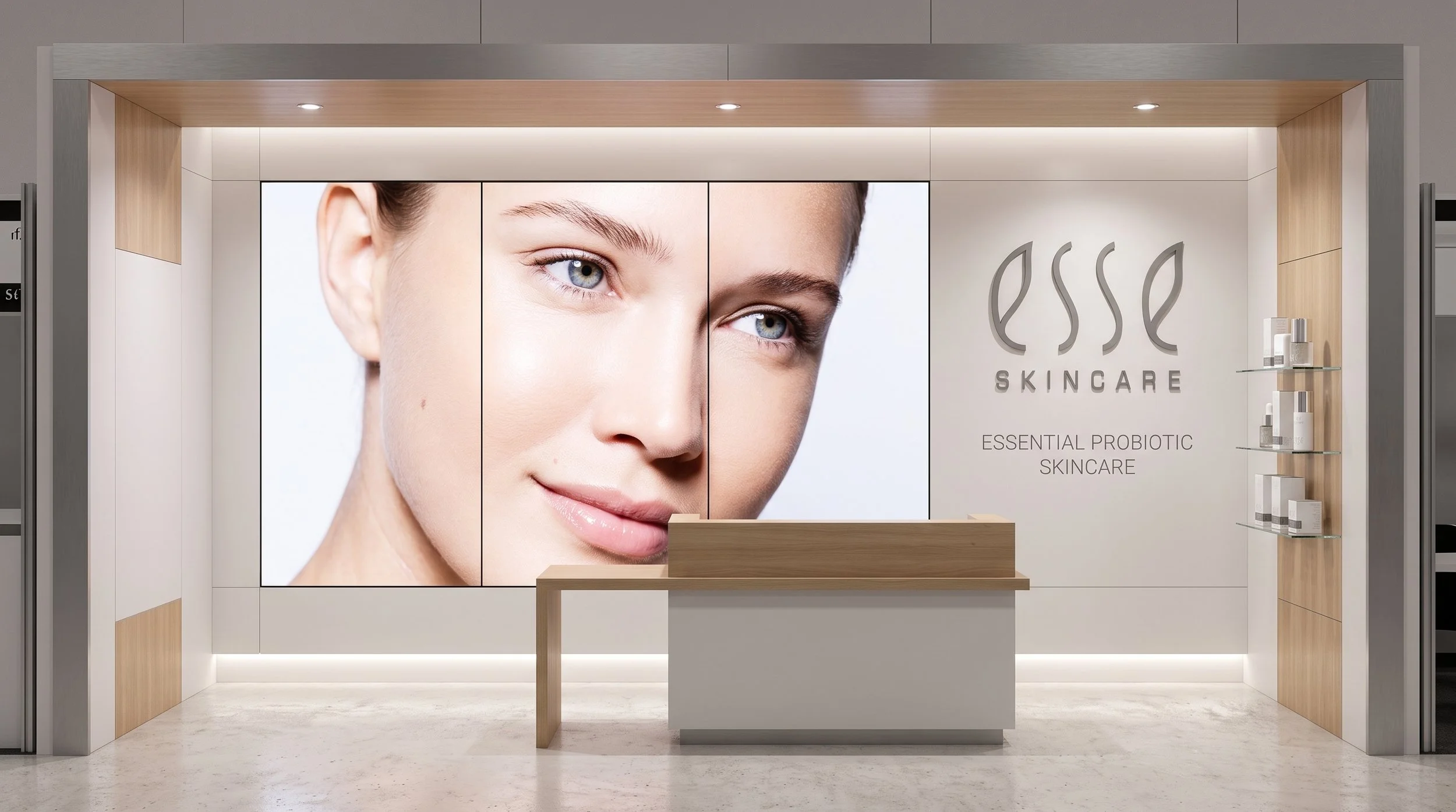 A modern commercial retail display booth with light wood and metallic accents. On the left, a large multi-panel digital screen displays a close-up portrait of a woman's face with clear skin. The right wall features a silver 'esse SKINCARE' logo above