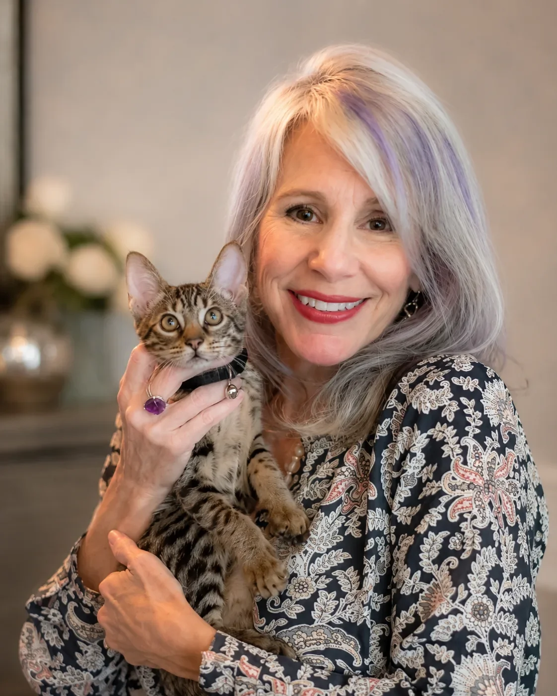 Cat, founder of Cat V. Atelier, smiling while holding her pet cat